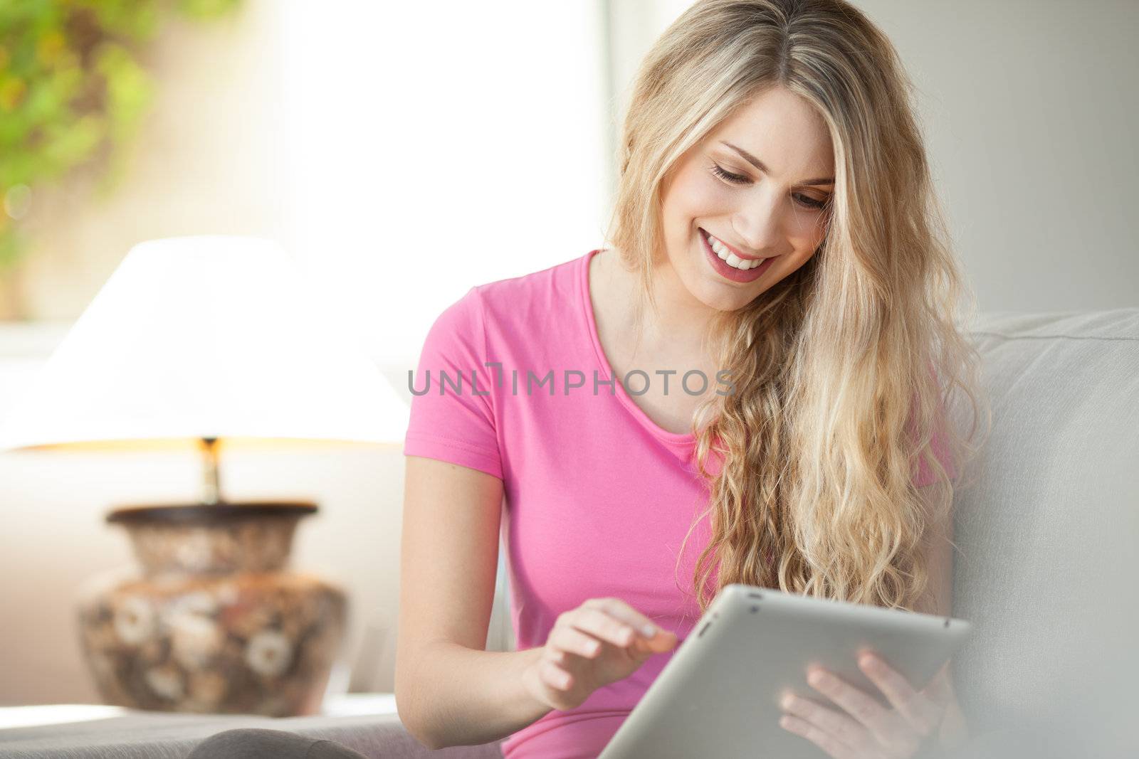 young beautiful woman using tablet at home by Lcrespi