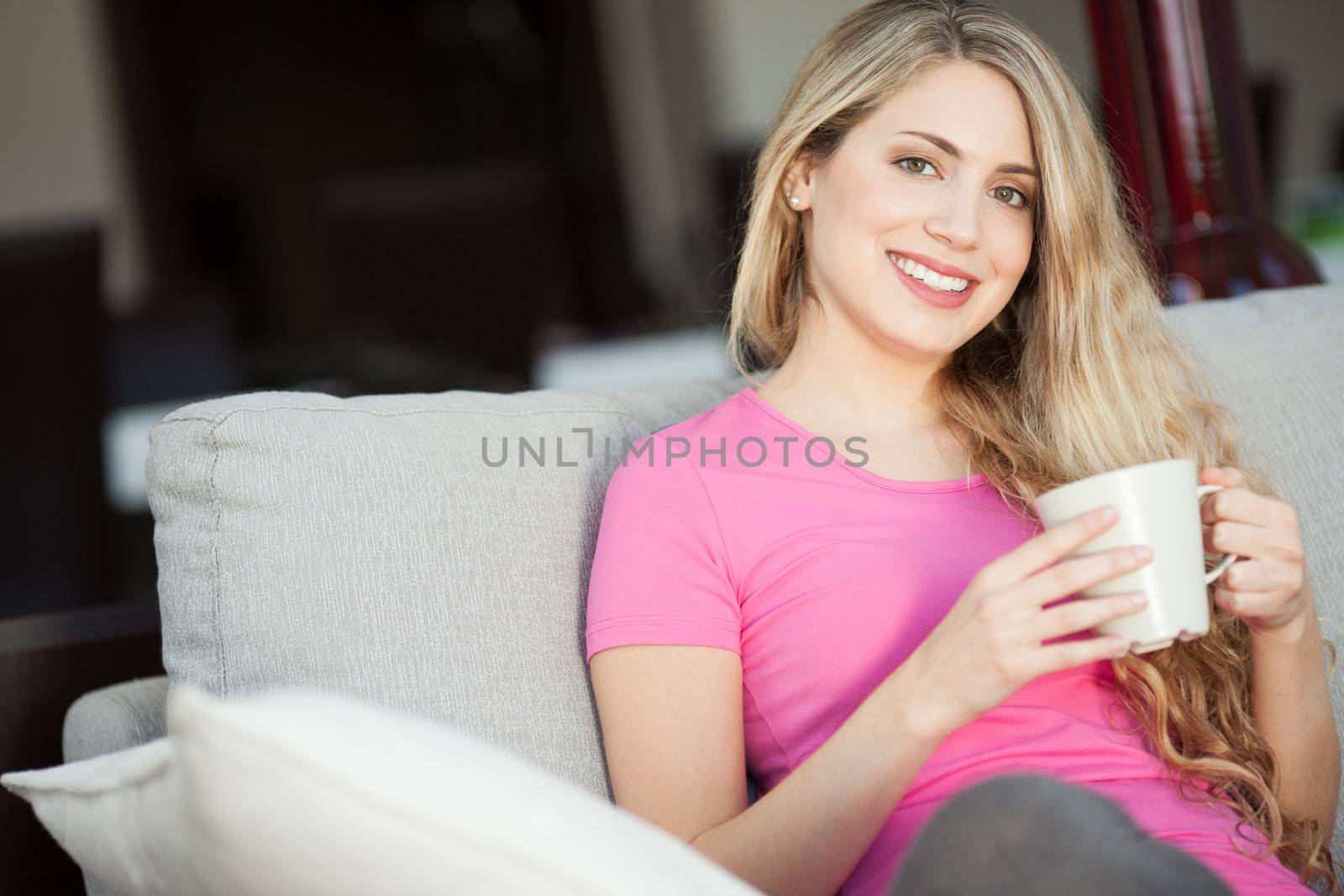 young beautiful woman with a cup on sofa by Lcrespi