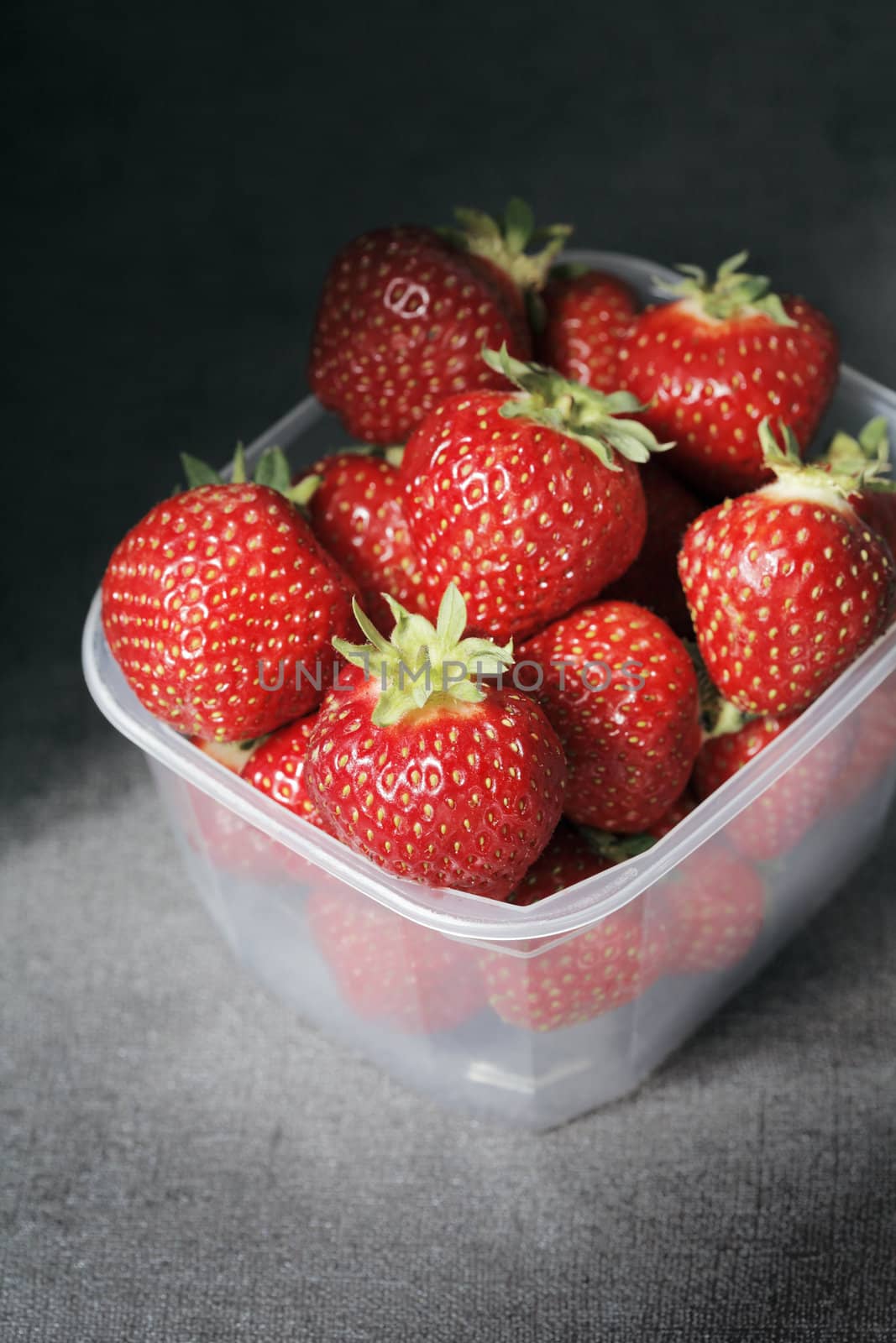 Strawberries in a plastic container. Short depth-of-field.