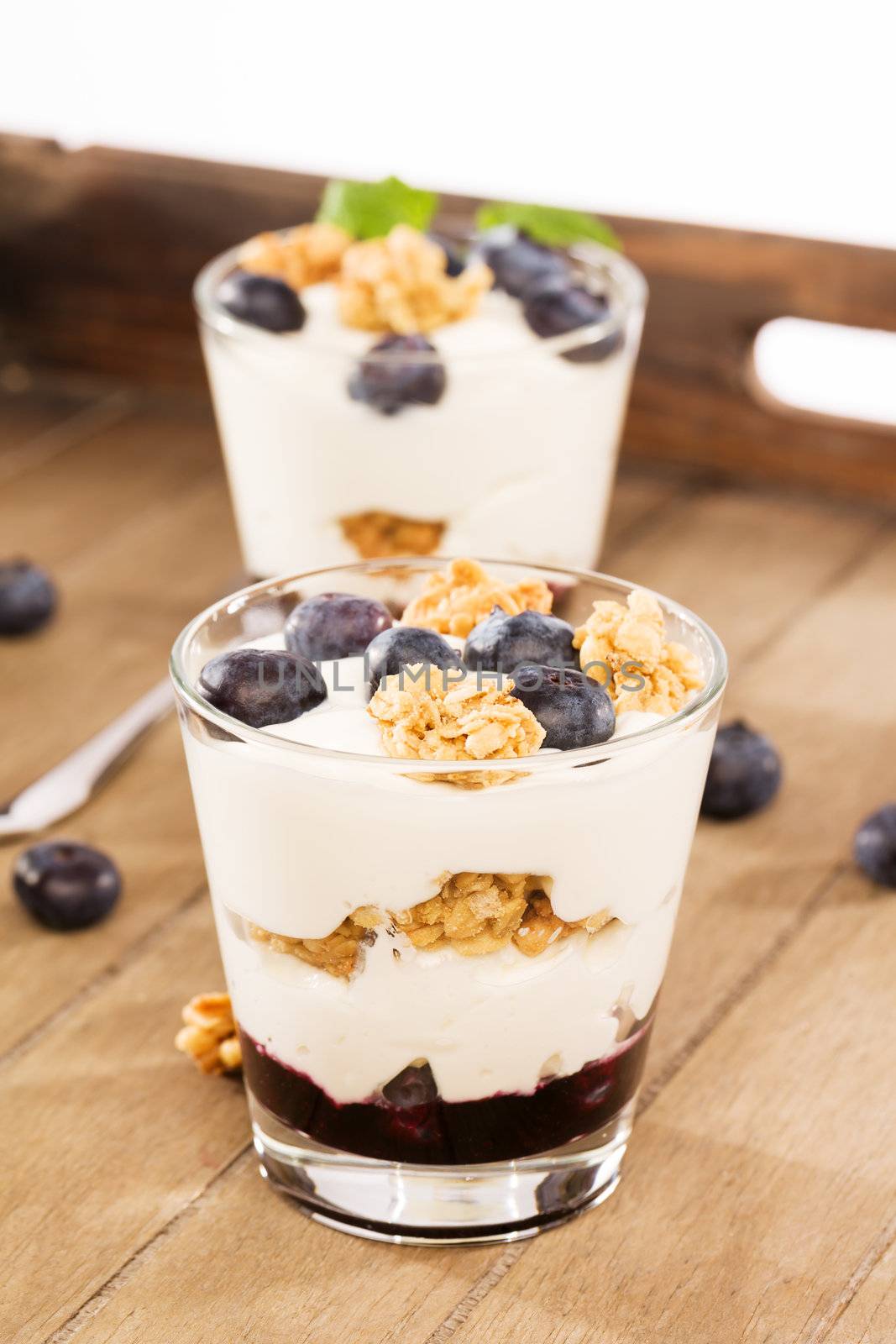 two blueberry yoghurt desserts on wooden background