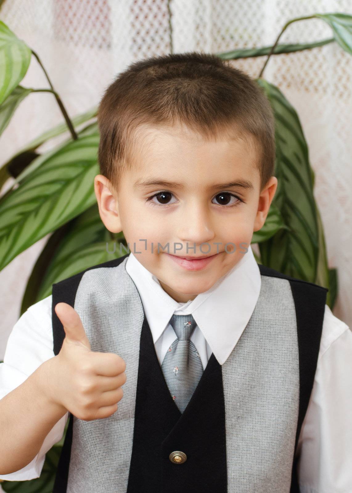 Cheerful little boy with thumbs up