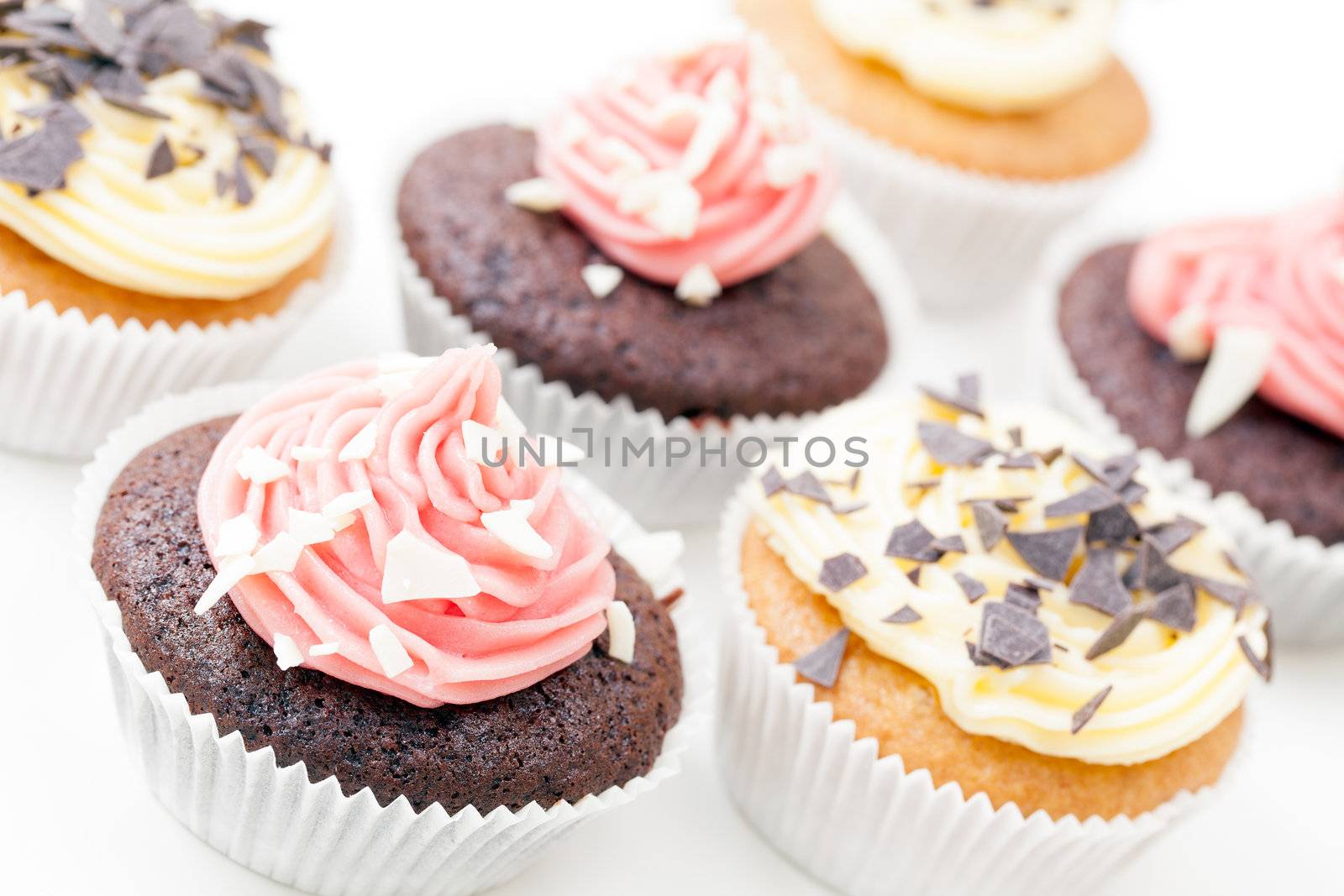 Chocolate and vanilla cupcakes frosted and topped with chocolate flakes.