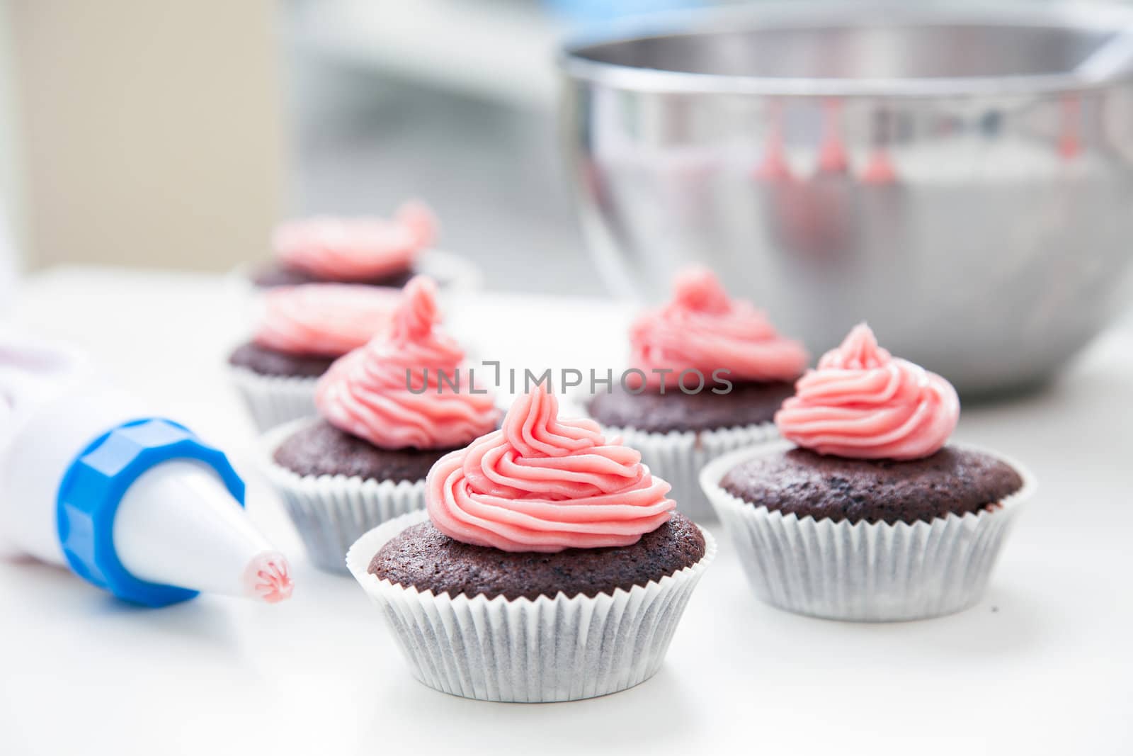 Chocolate cupcakes just decorated with pink frosting