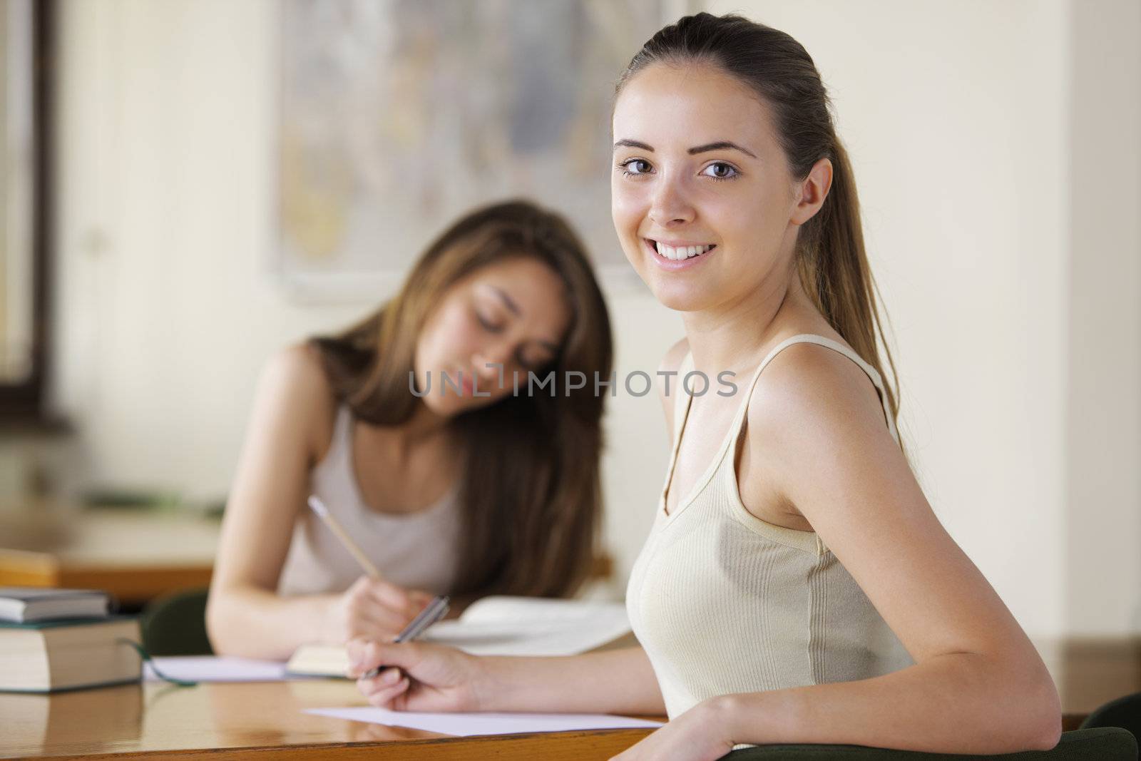 Portrait of a student, a young woman studying in the background