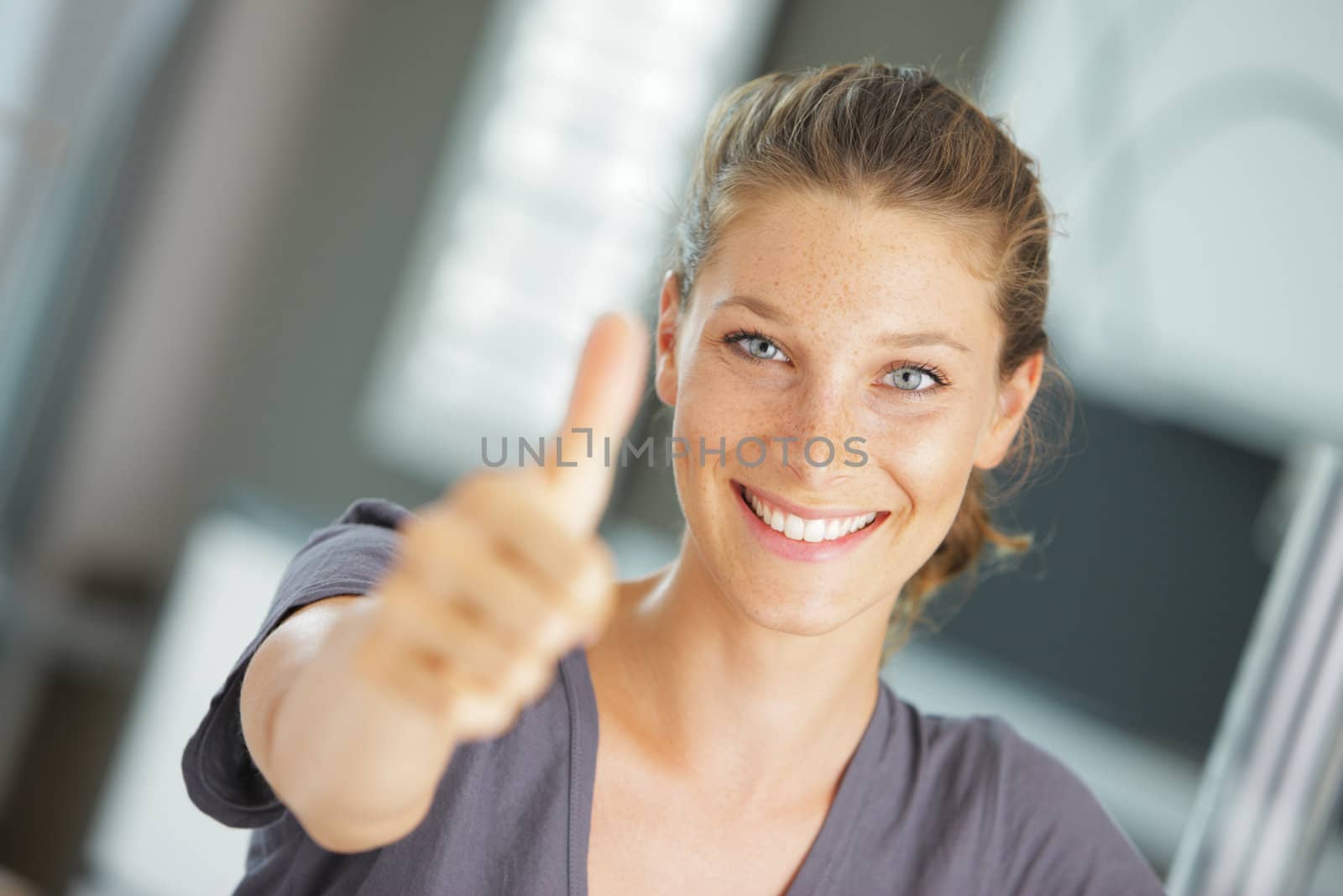 Portrait of beautiful young woman holding a thumbs up to the camera