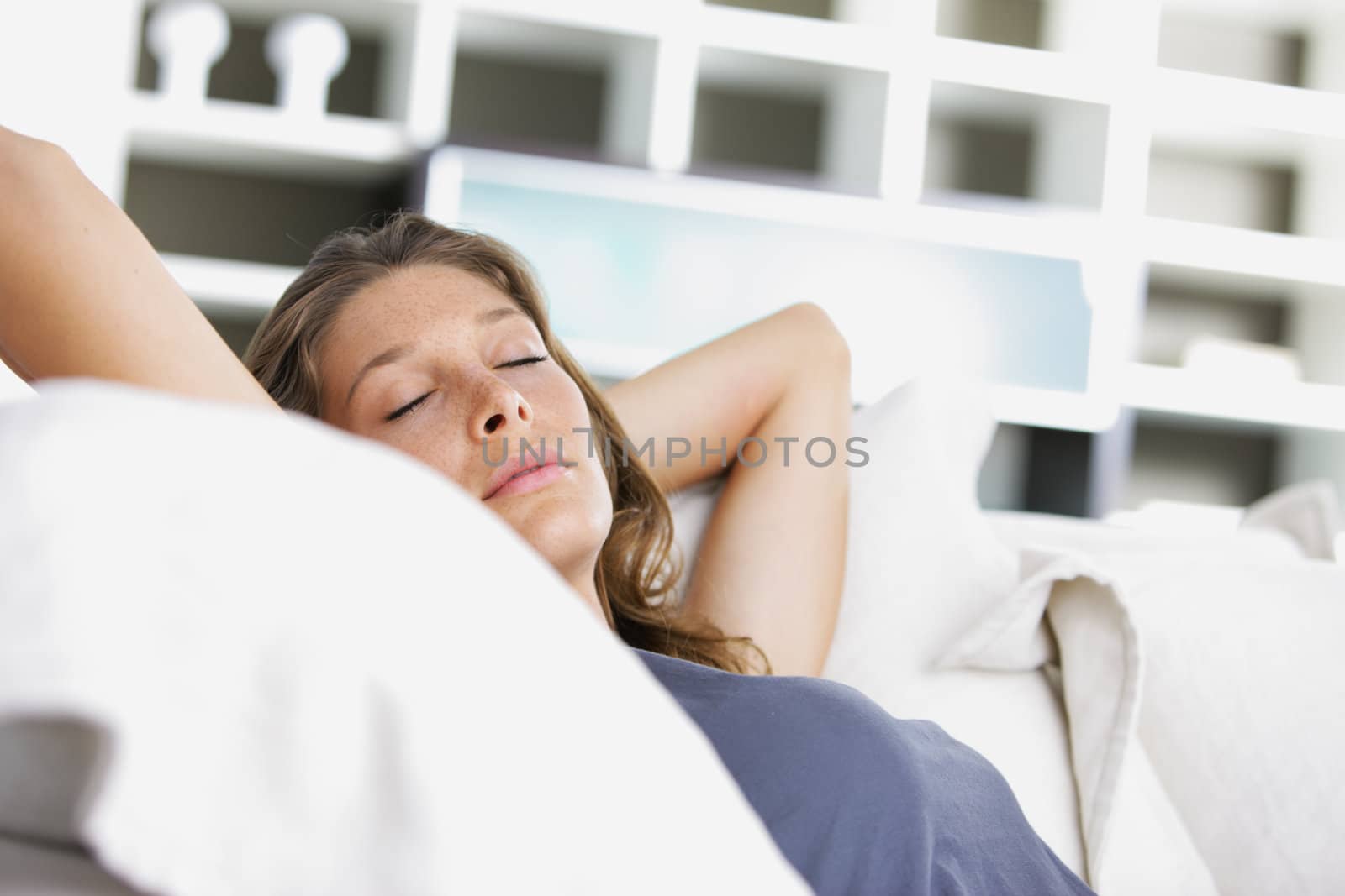 Young beautiful woman sleeping on white couch