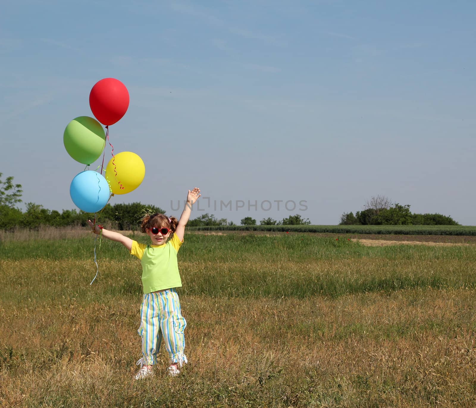 happy little girl with colorful balloons