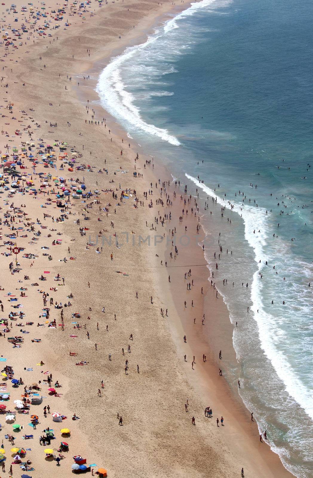 Sunny day in Nazare with a lot of people on the beach
