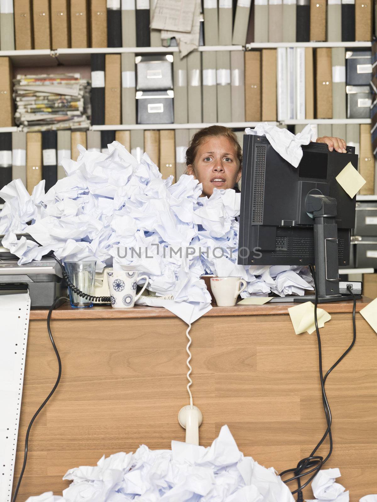 Businesswoman overloaded with papers at the messy office