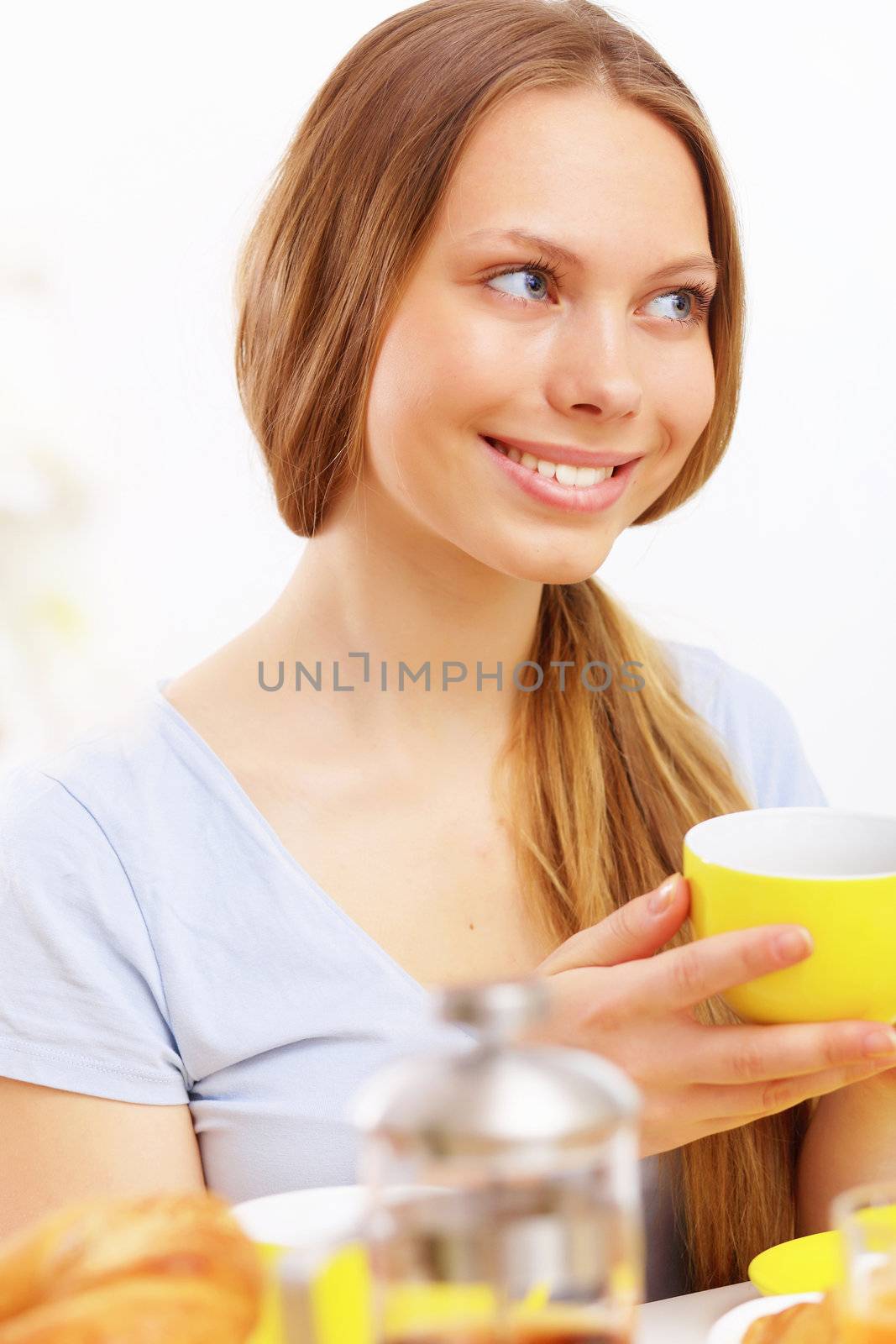 Beautiful young woman drinking tea from yellow cup