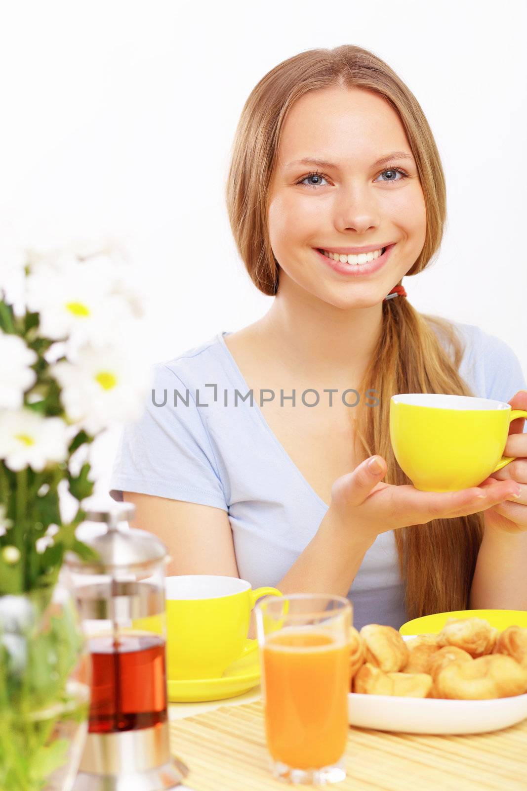 Beautiful young woman drinking tea from yellow cup