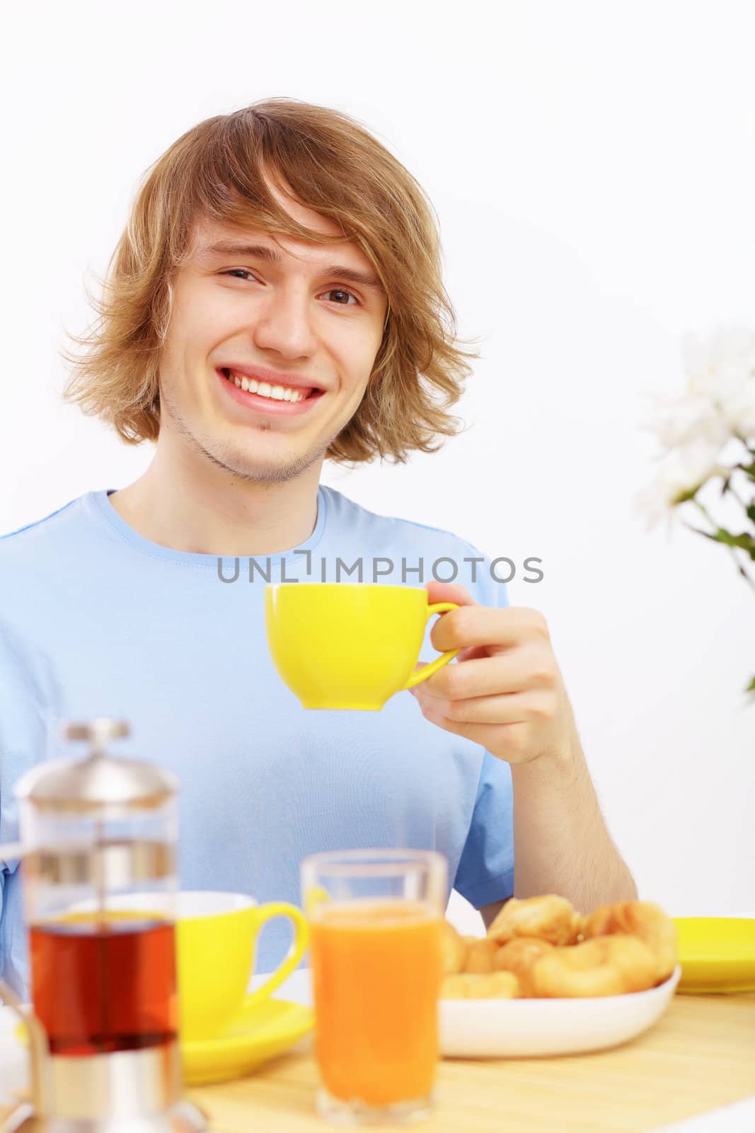 Young happy man drinking tea at home