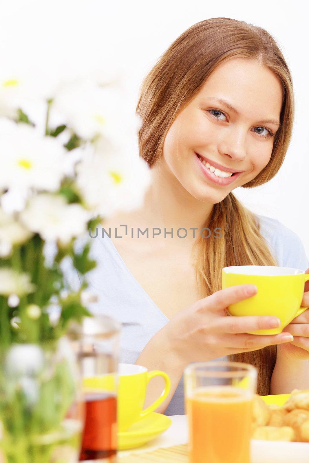 Beautiful young woman drinking tea from yellow cup