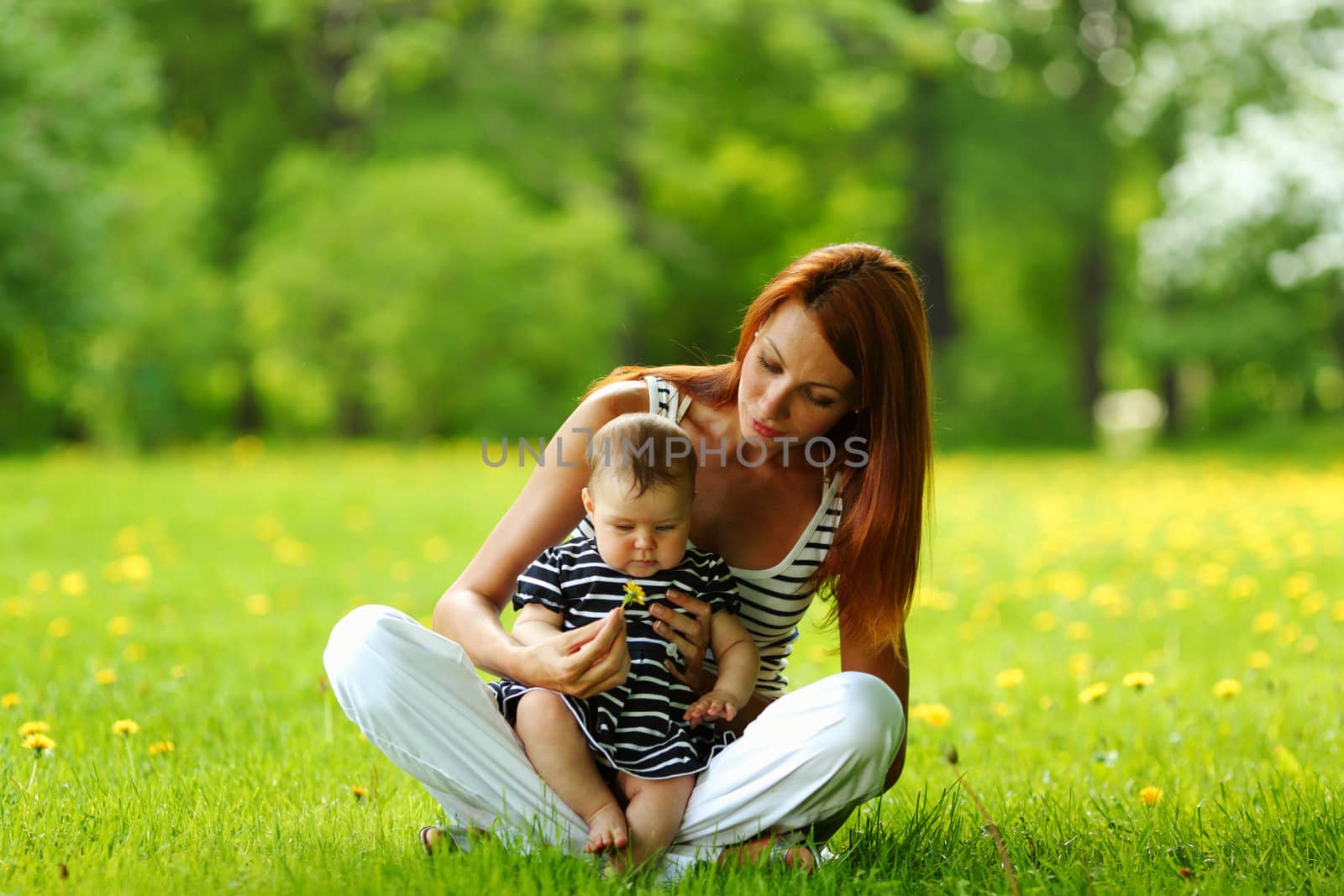 Happy mother and daughter on the green grass