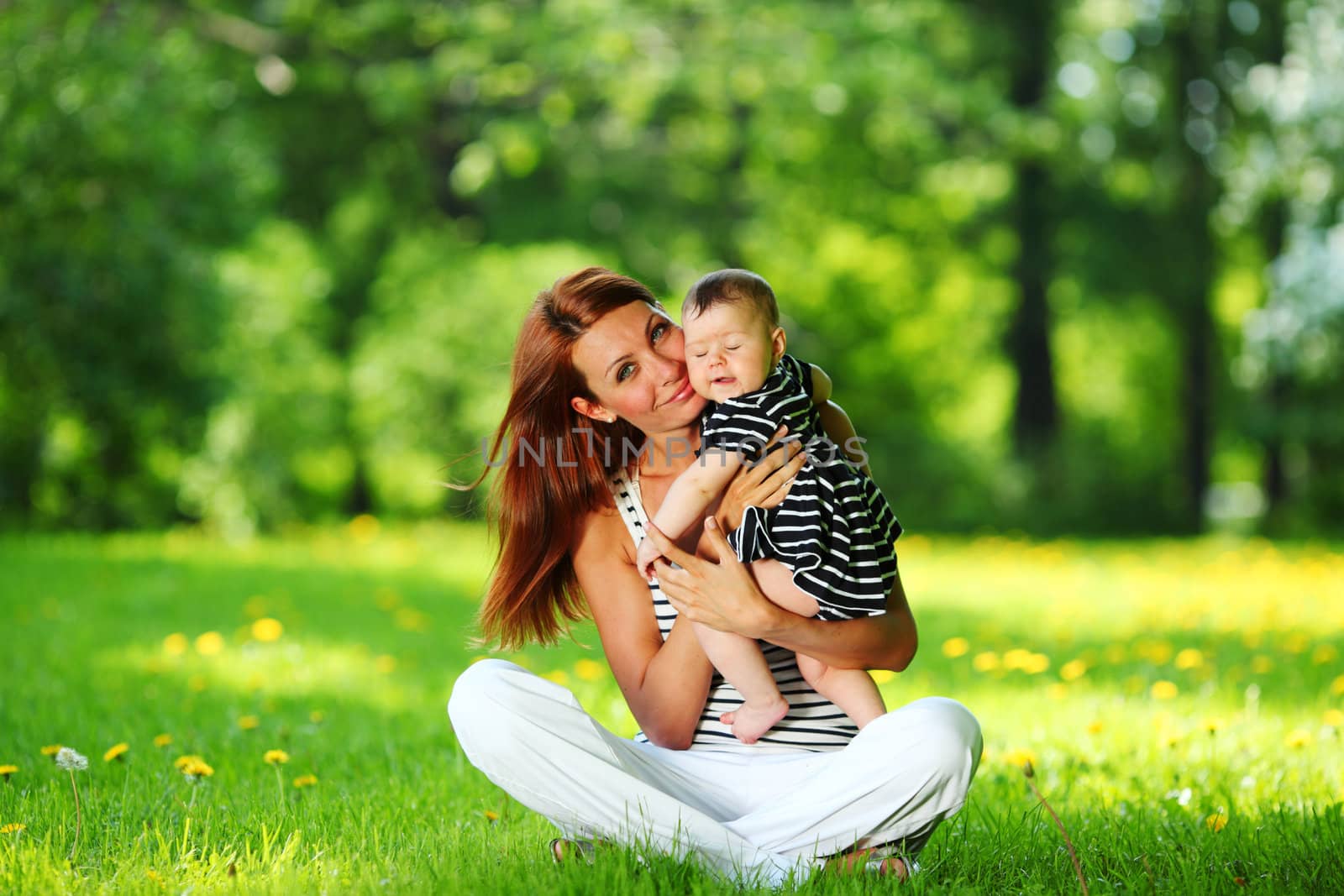 Happy mother and daughter on the green grass