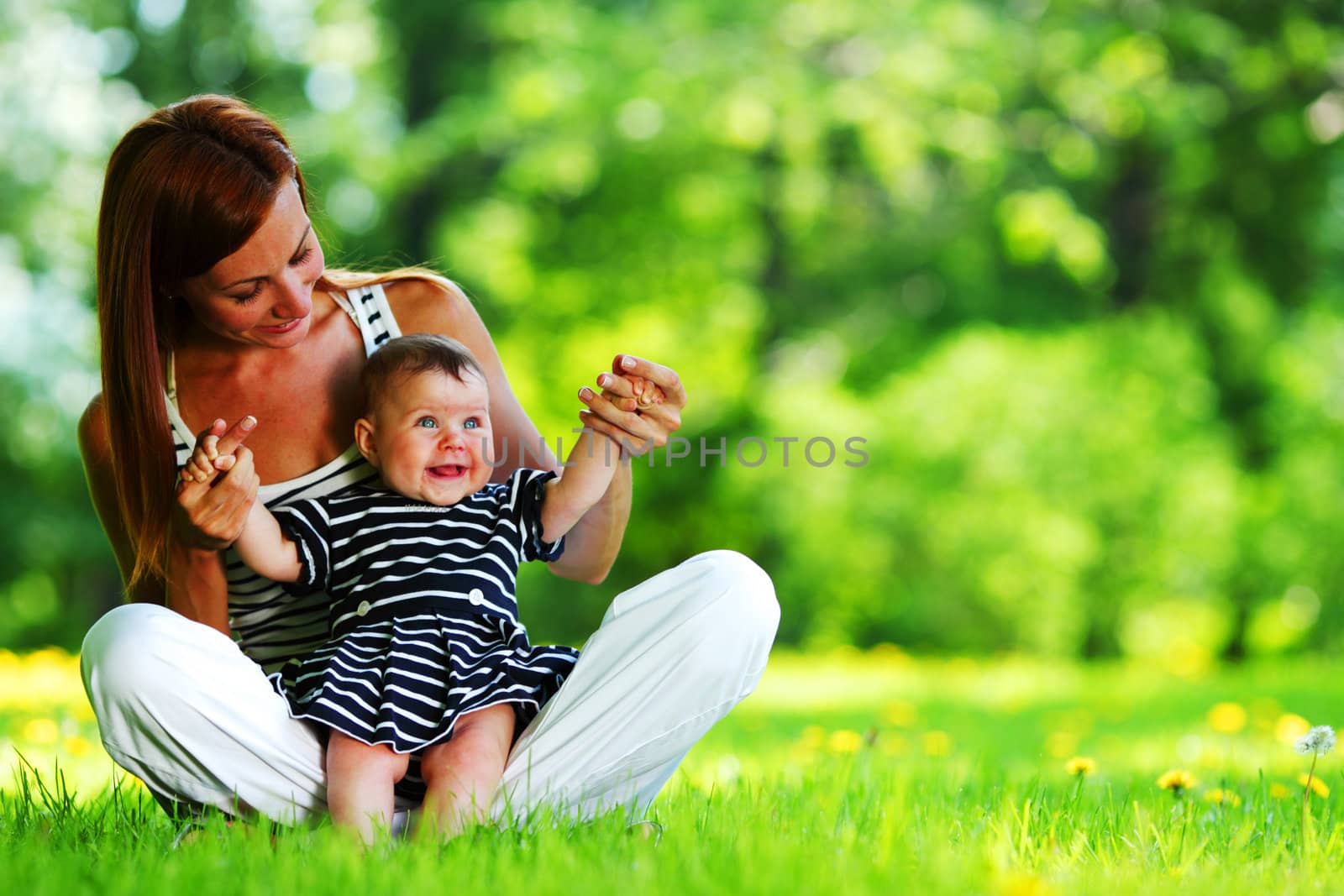 Happy mother and daughter on the green grass