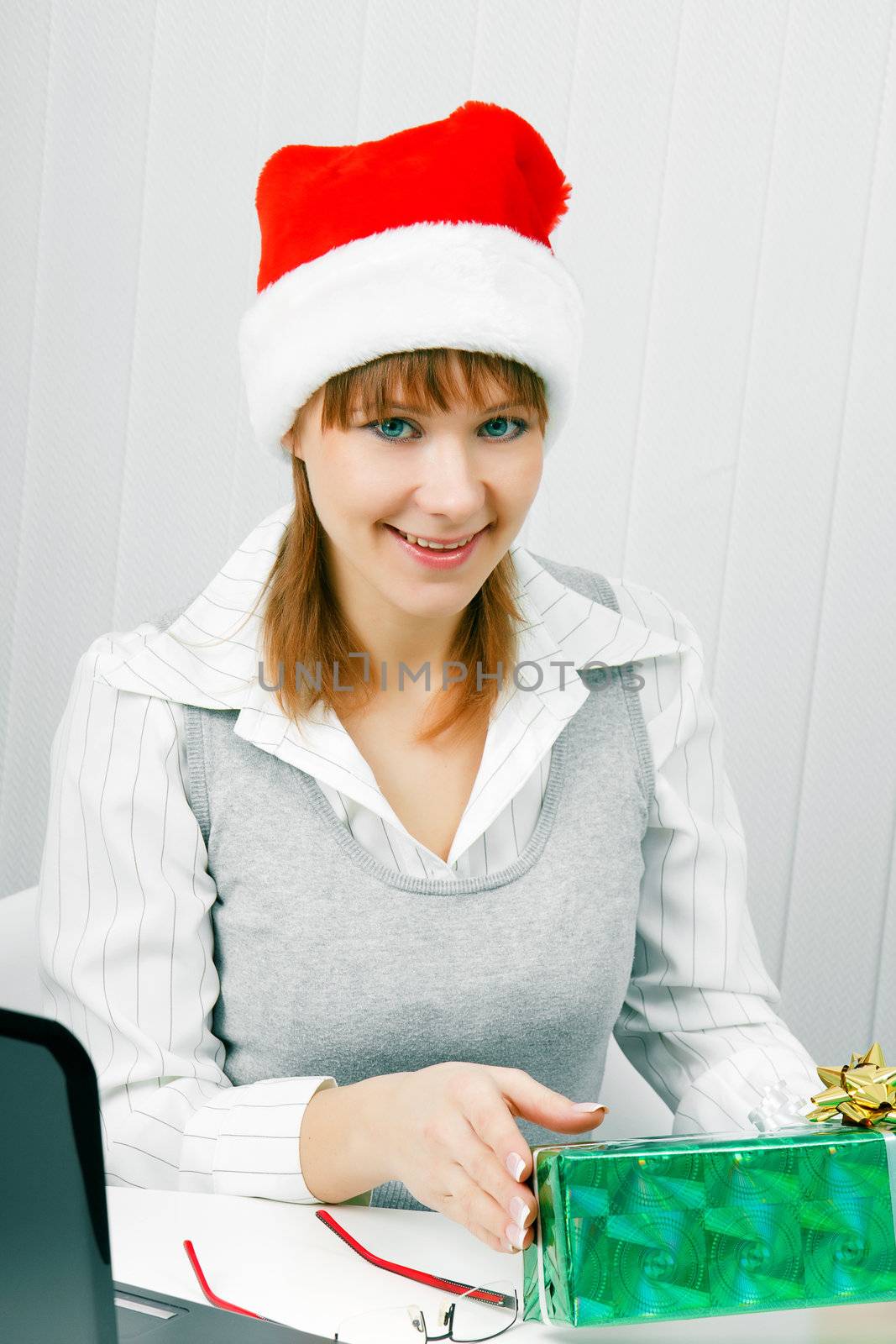 Attractive girl in the office with a Christmas present