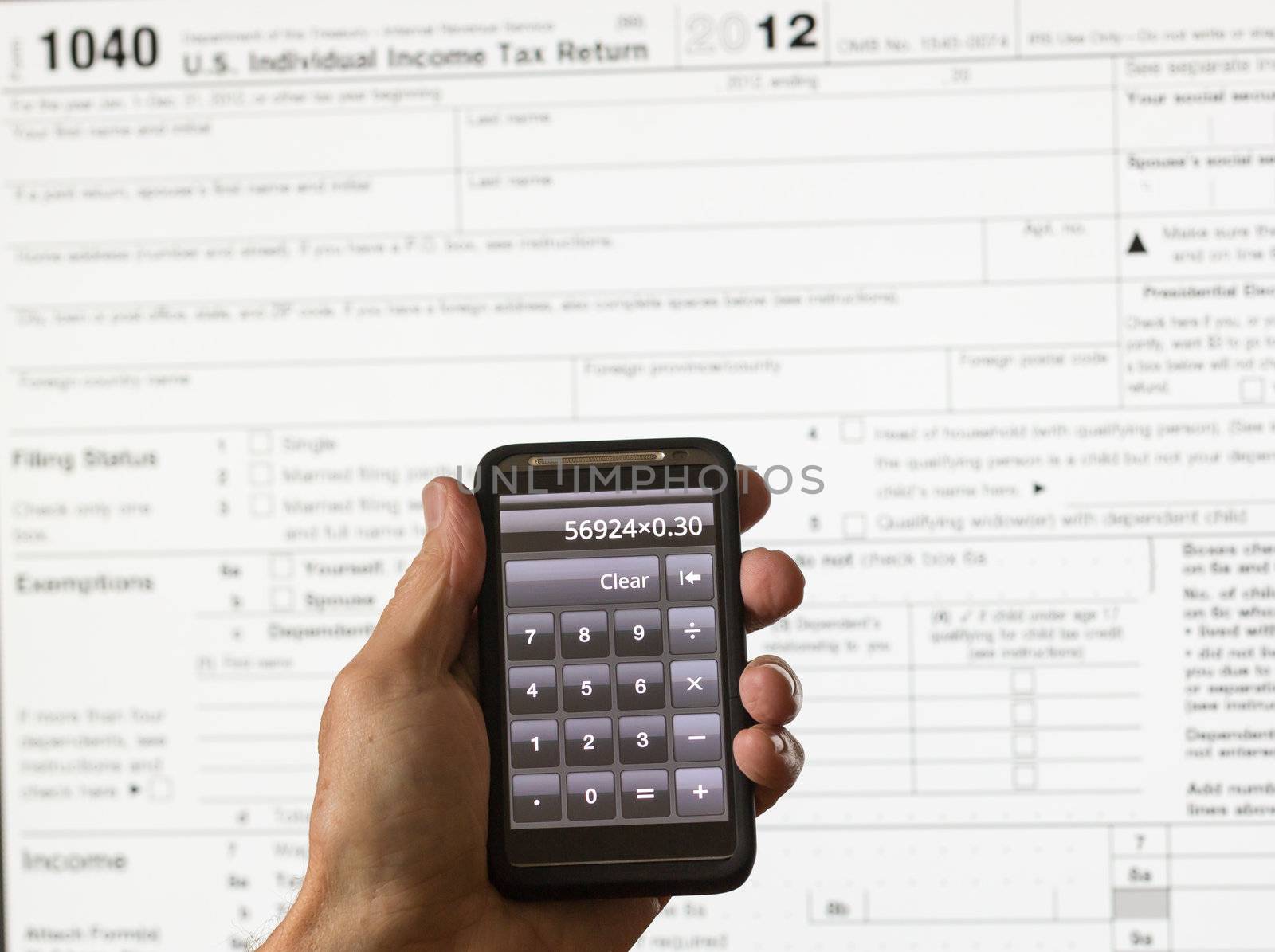 Electronic tax form 1040 for 2012 for US individual return on screen with smartphone calculator