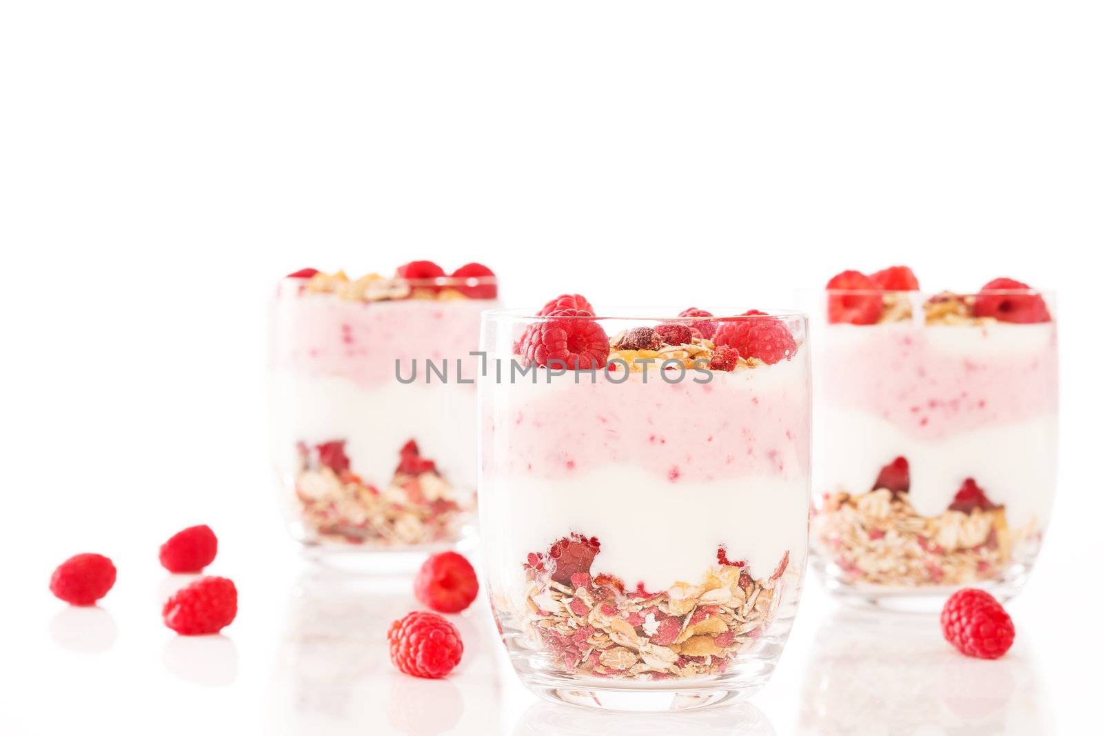 muesli yoghurt dessert wih raspberries on white background
