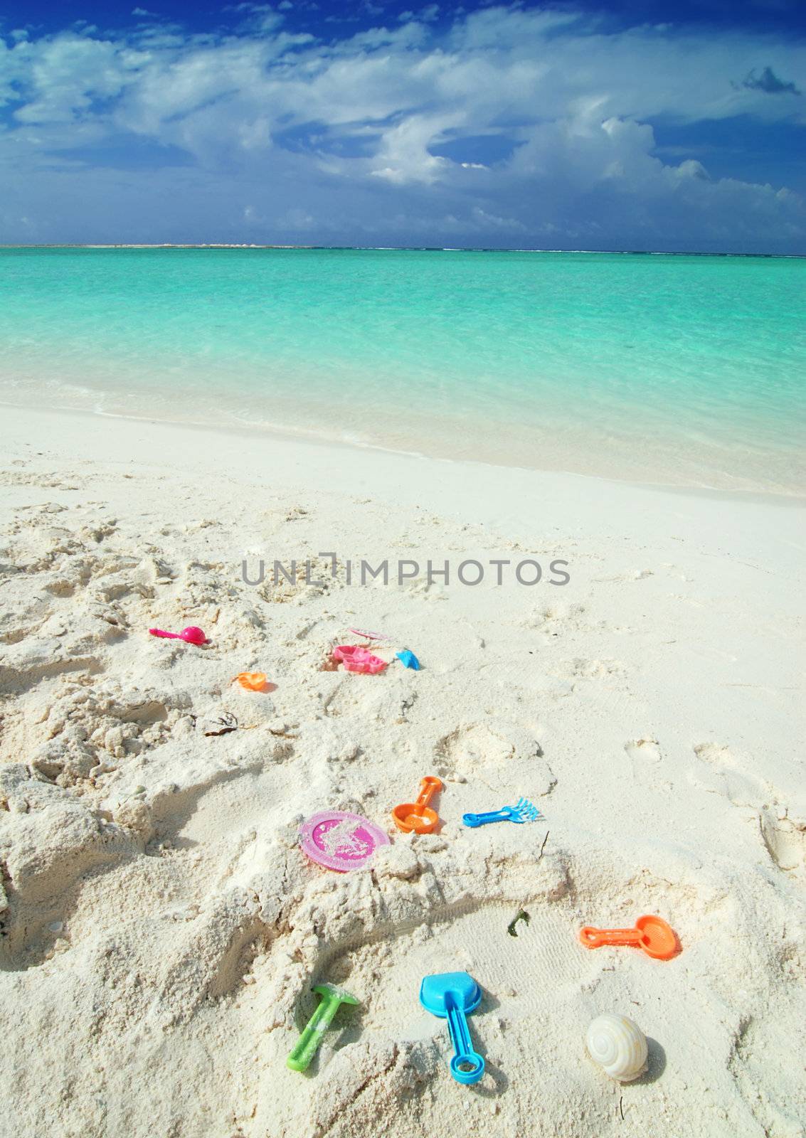 Colorful child toys laying on the beach in the Maldives