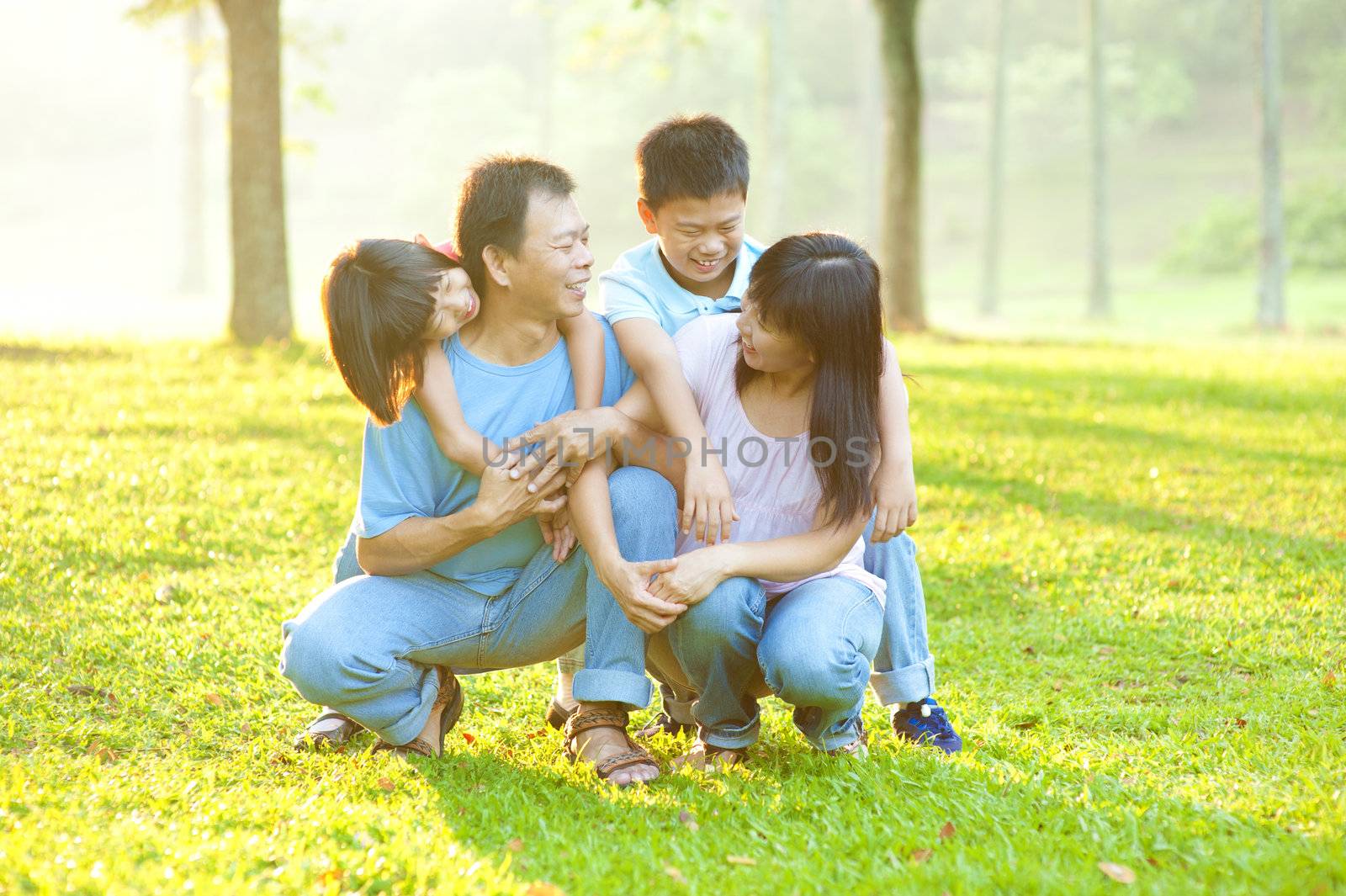 Happy Asian family having conversation at outdoor park