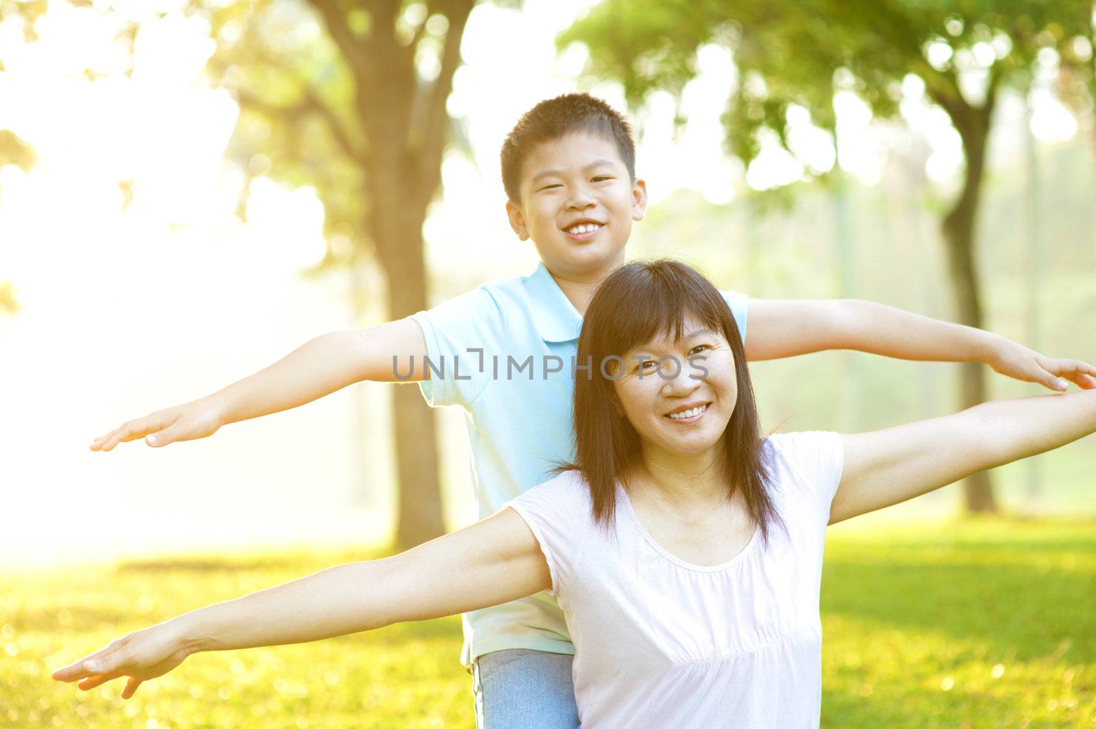 Asian mother and child happy playing on tropical park