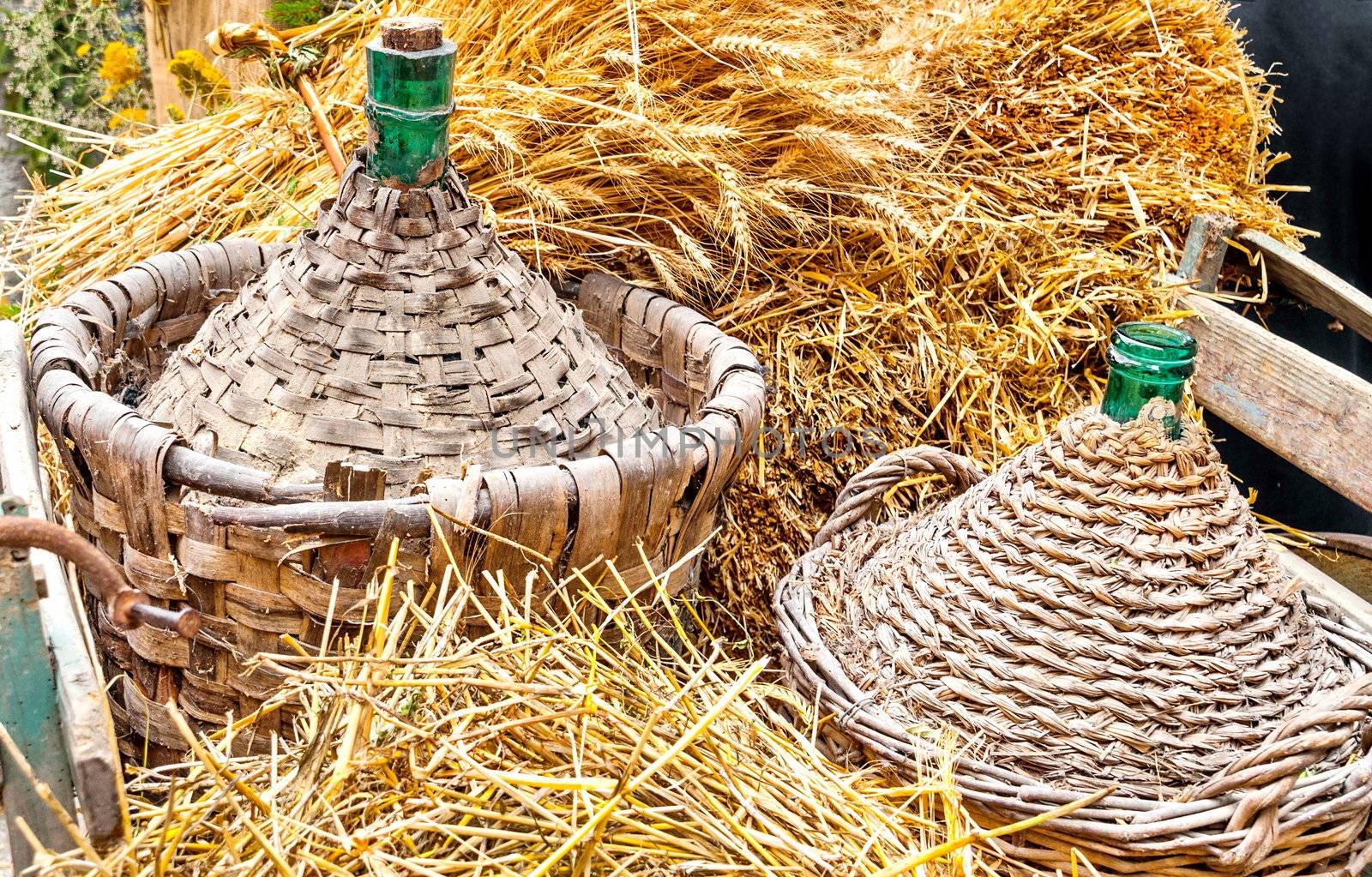 Autumn harvest demijohn wicker with bales of hay