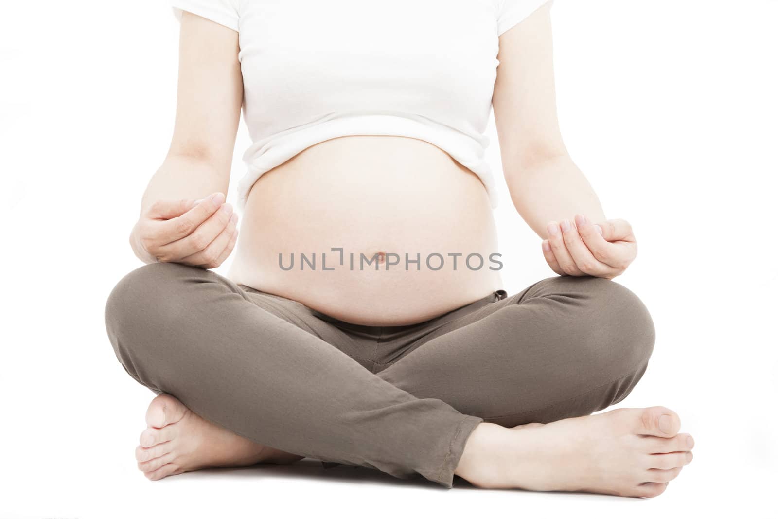 pregnant woman doing yoga meditating exercise by tomwang