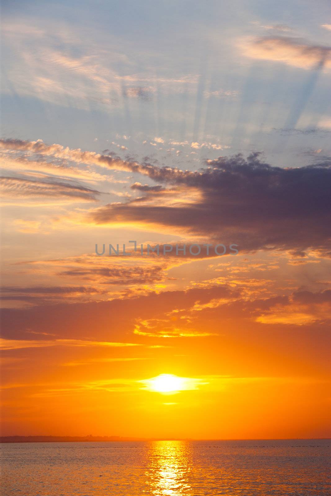 sunset with clouds and rays on the sea