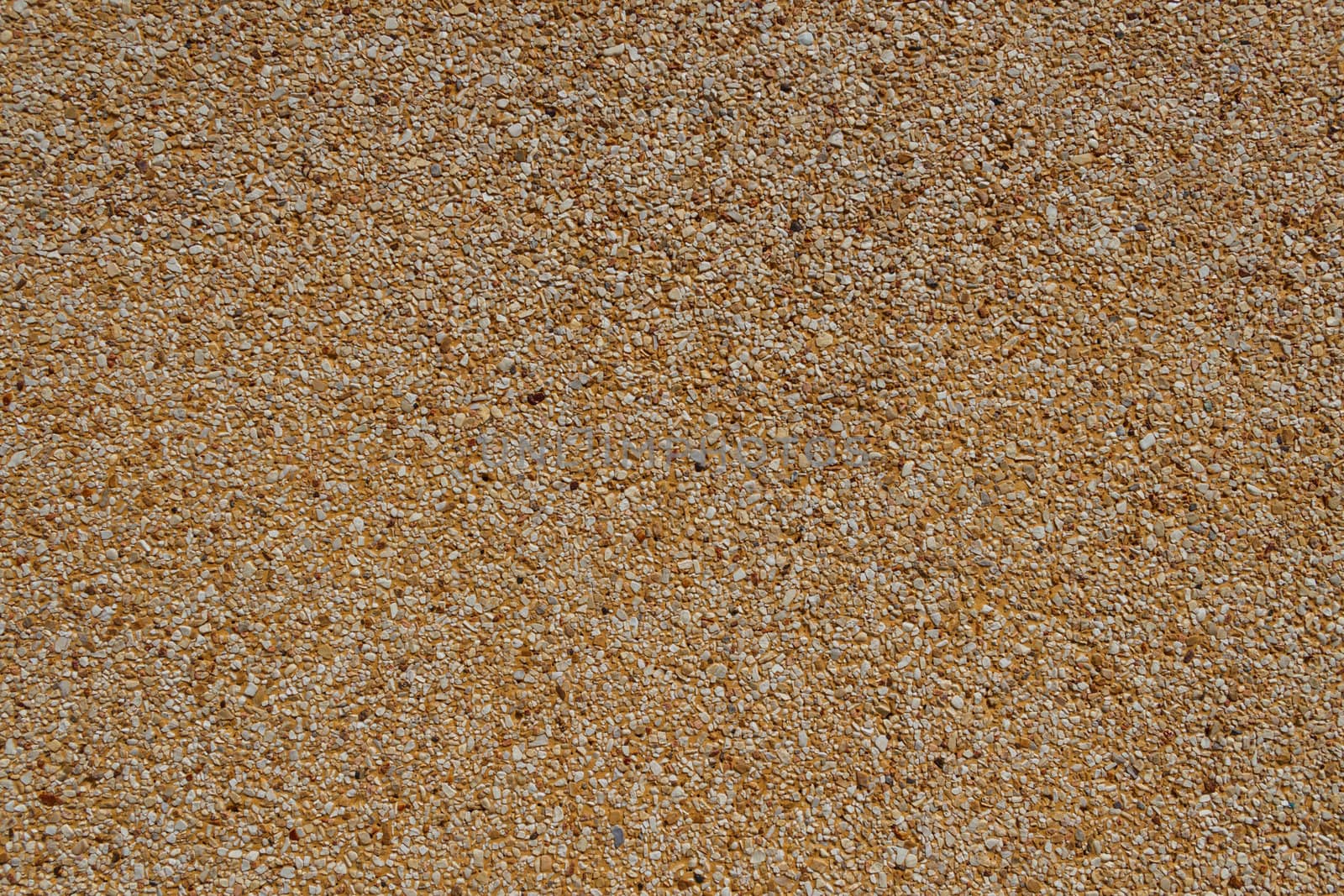 Tiny gravel texture on brown concrete wall in sunny day