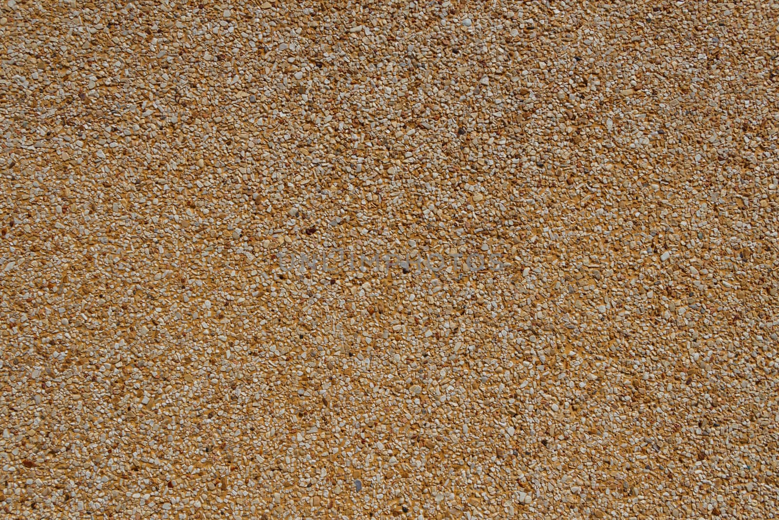 Tiny gravel texture on brown concrete wall in sunny day