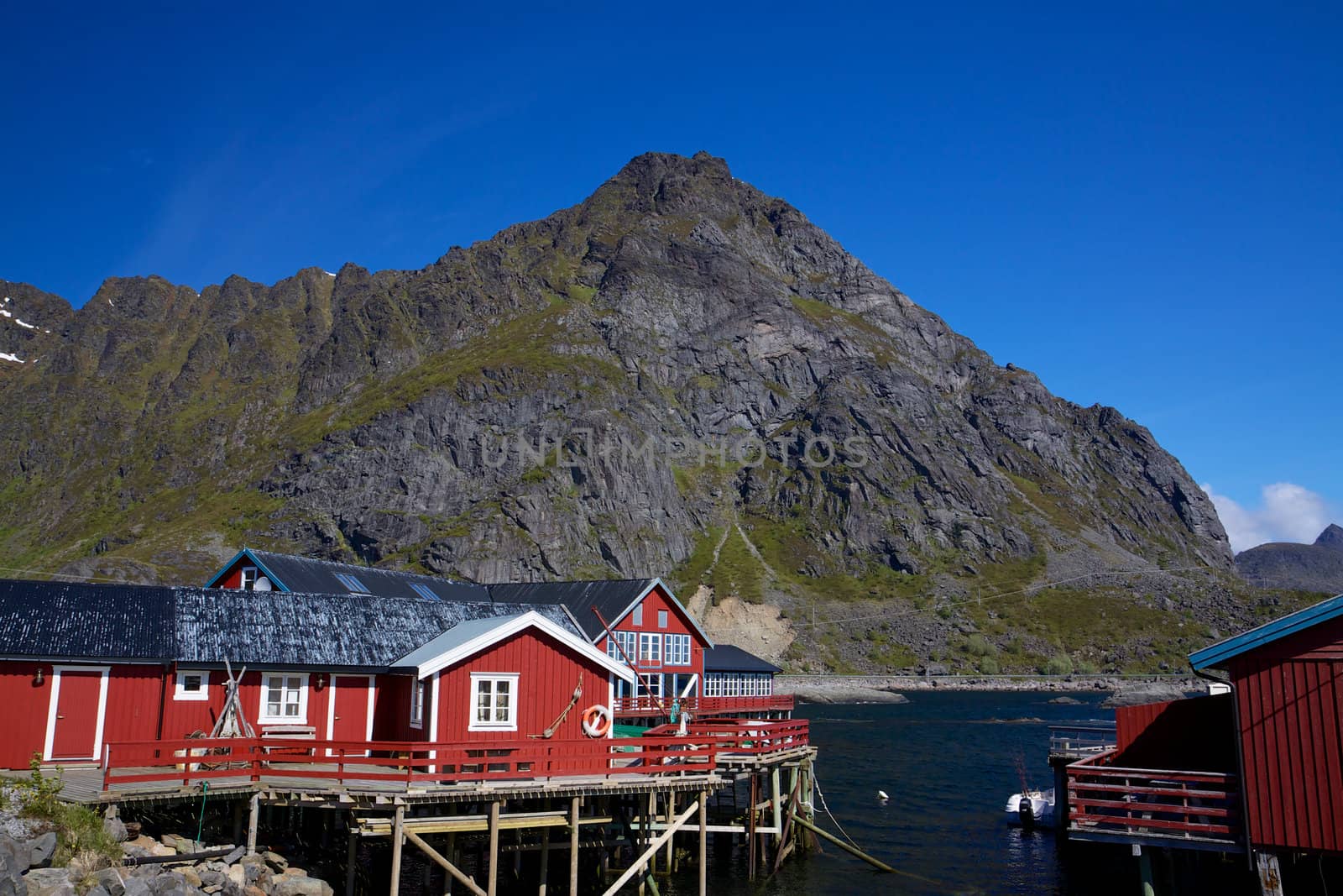 Typical red rorbu fishing huts by fjord on Lofoten islands in Norway 