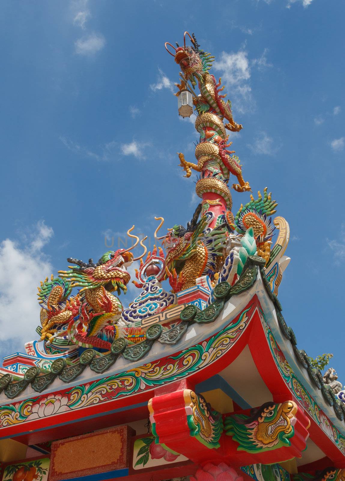 Symbolic of Chinese shrine is golden dragon. In general, two golden dragon are on the rooftop and another is on the top of the red pillar with the sacred lantern. The photo is taken at Chinese shrine in Bangkok, Thailand.