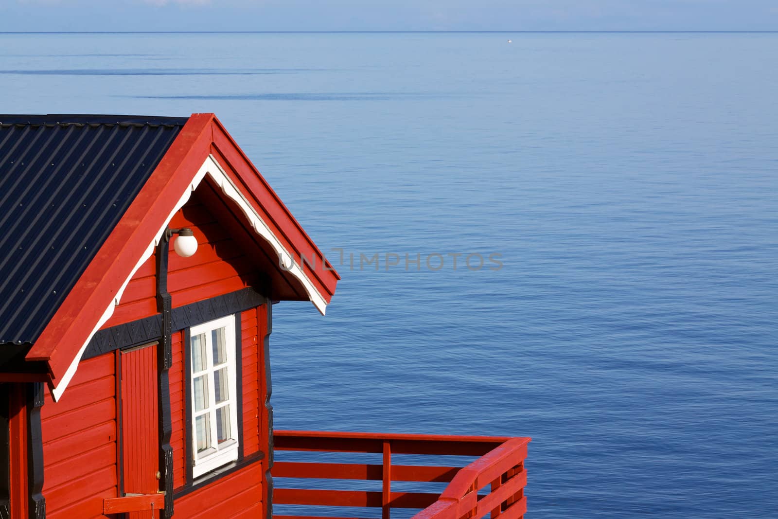 Typical red fishing hut on the coast of fjord on Lofoten islands in Norway
