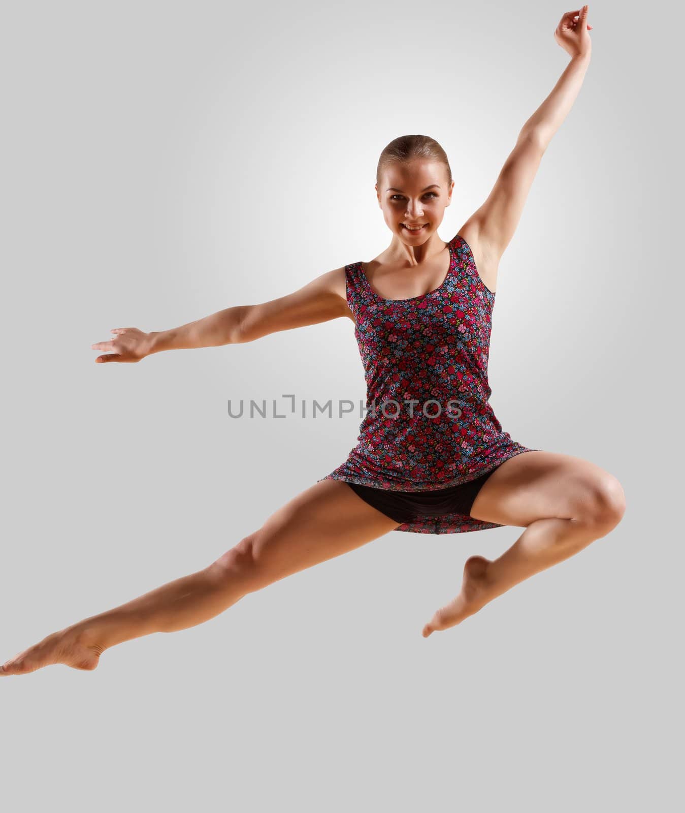 Girl dancing in a color dress with a gray background. isolate
