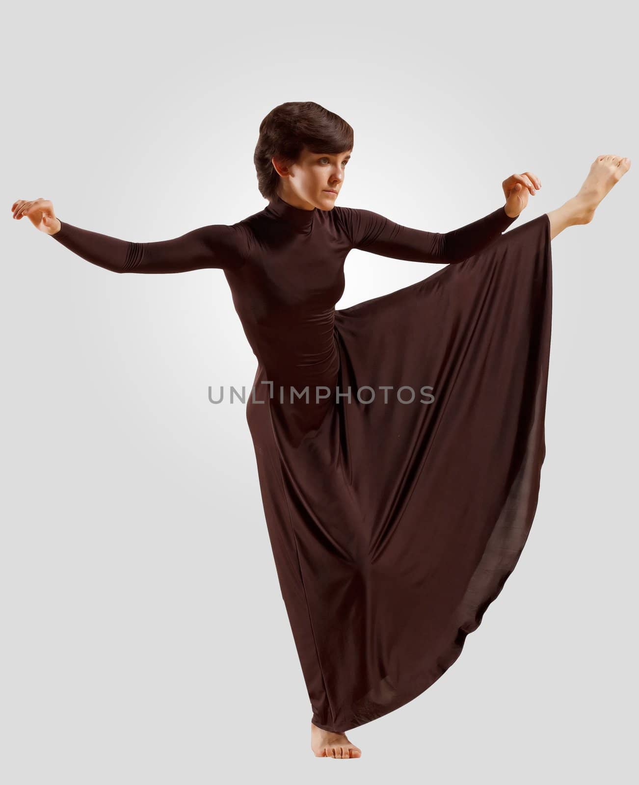 Girl dancing in a dark dress with a gray background. isolate