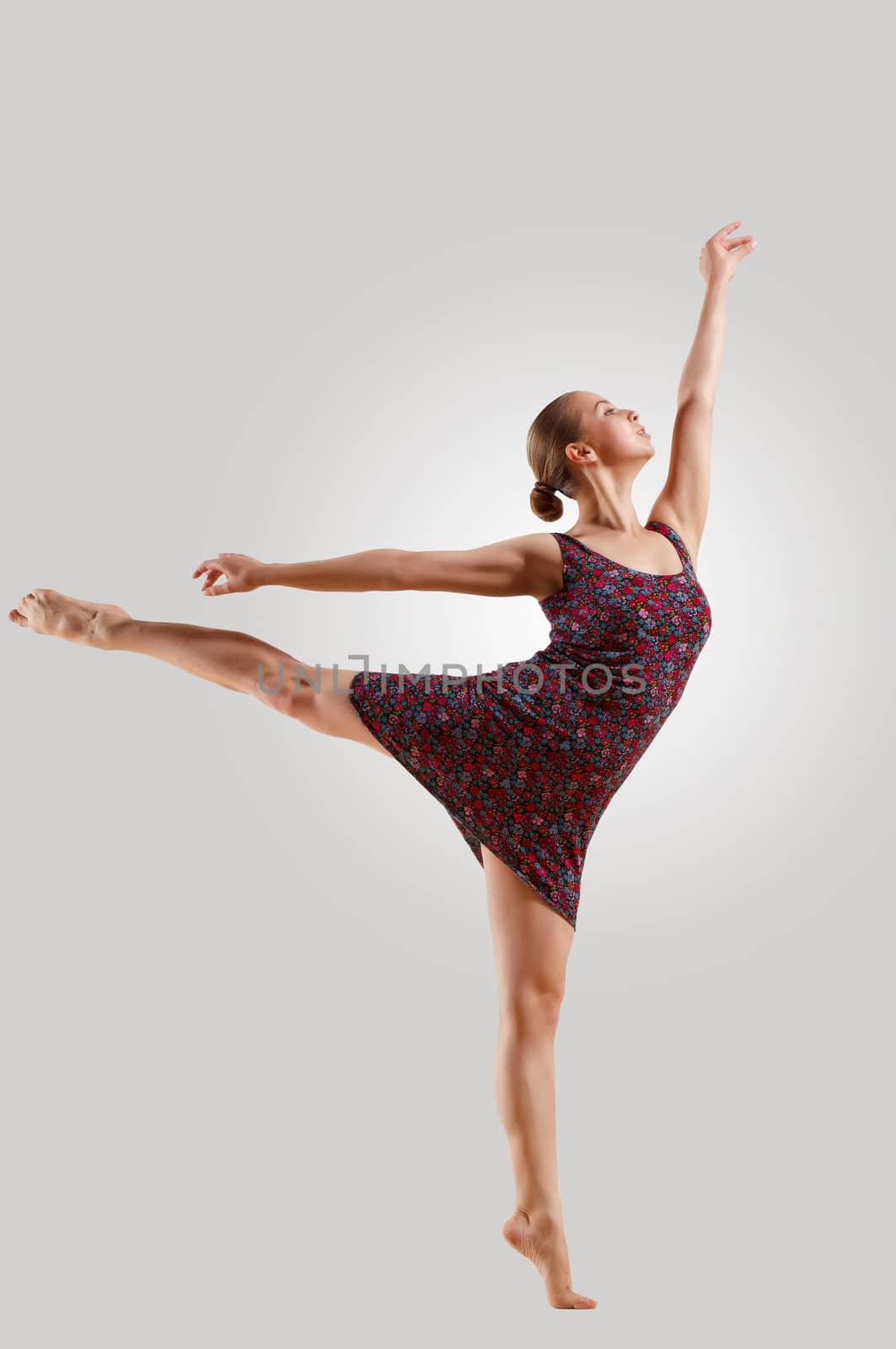 Girl dancing in a color dress with a gray background. isolate