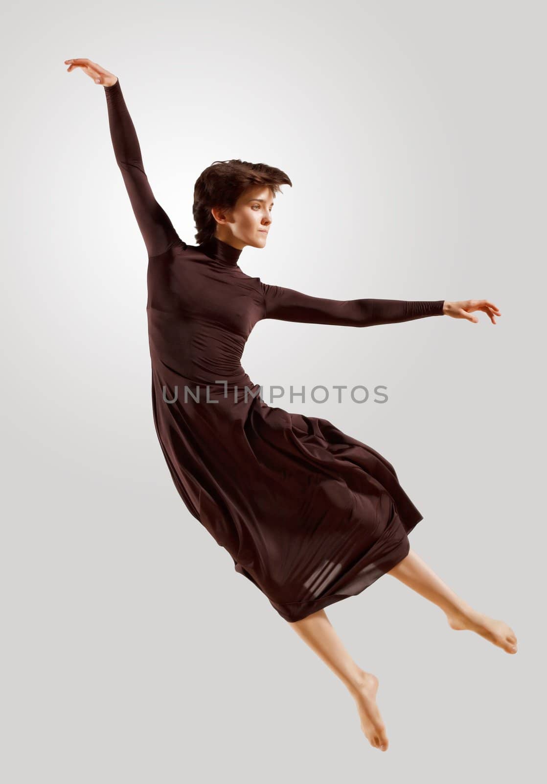 Girl dancing in a dark dress with a gray background. isolate