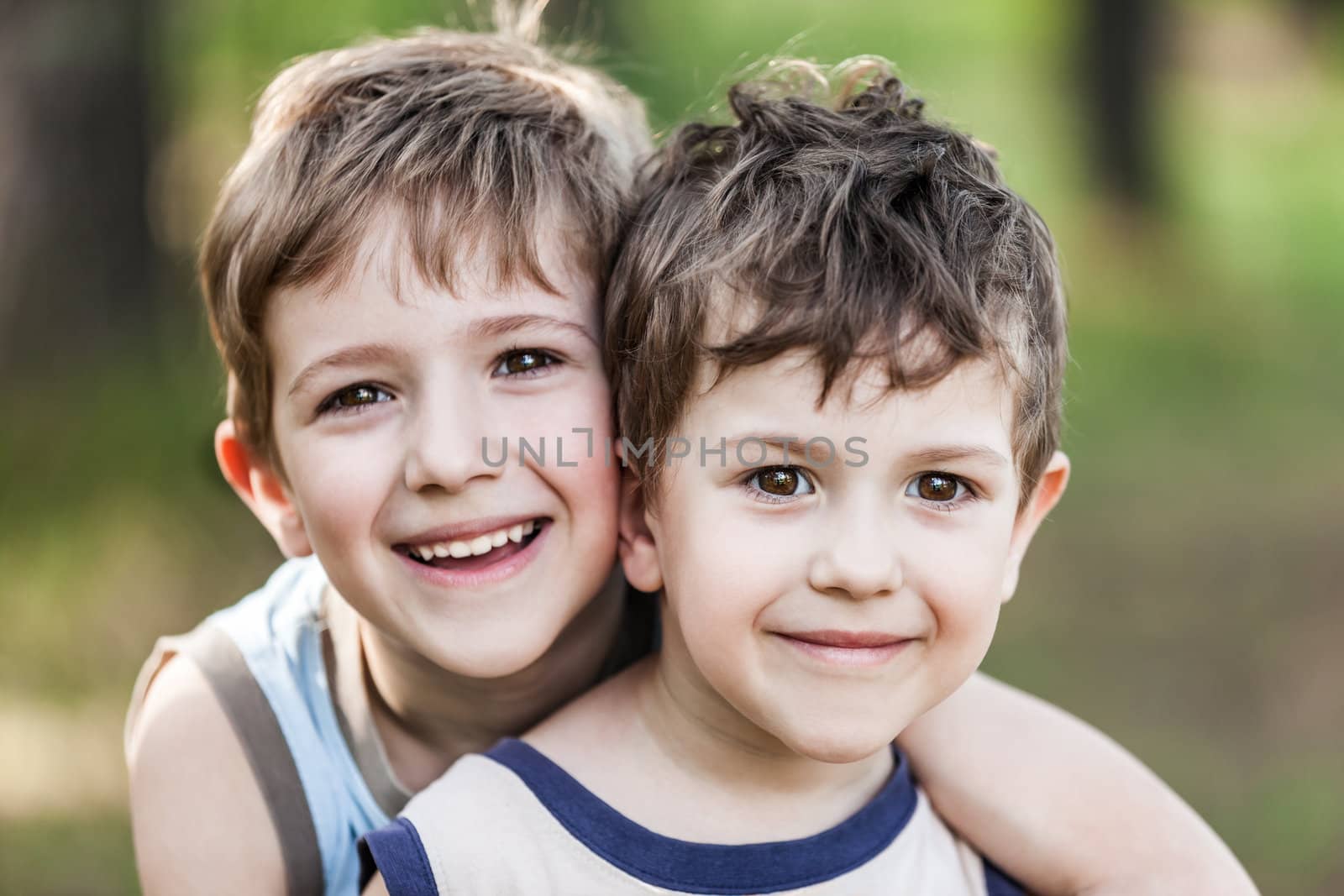 Family happiness - two little smiling child boy brothers walking outdoor