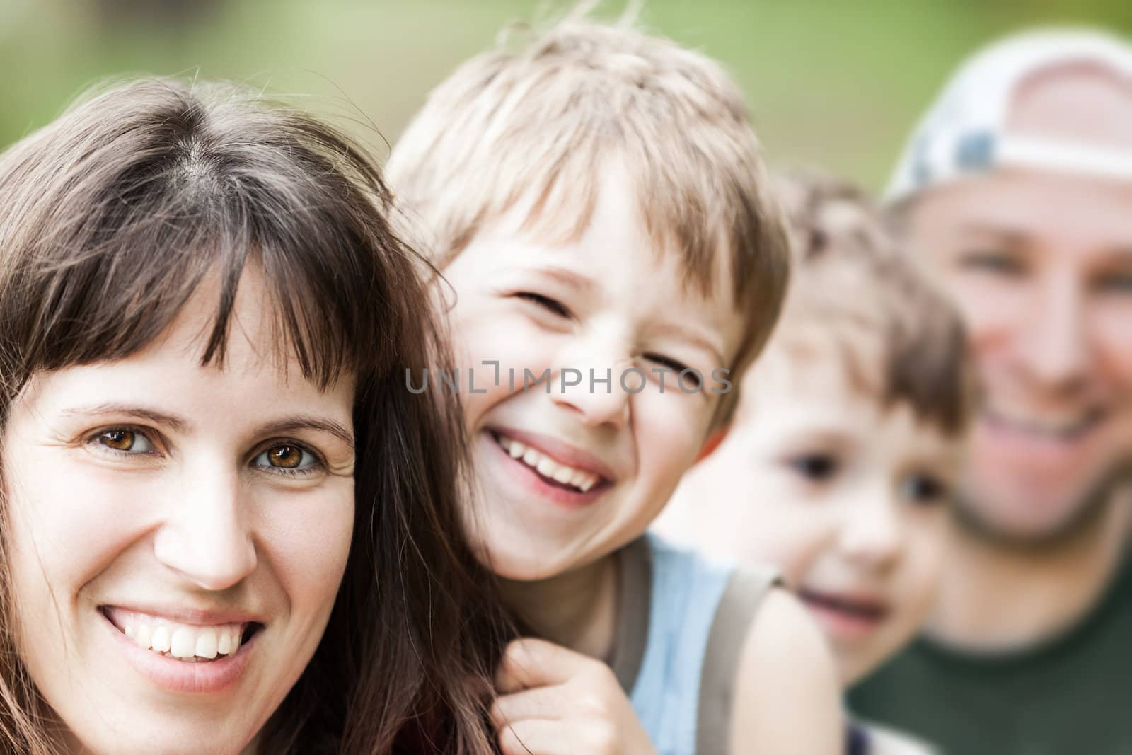Smiling couple and little sons - family happiness