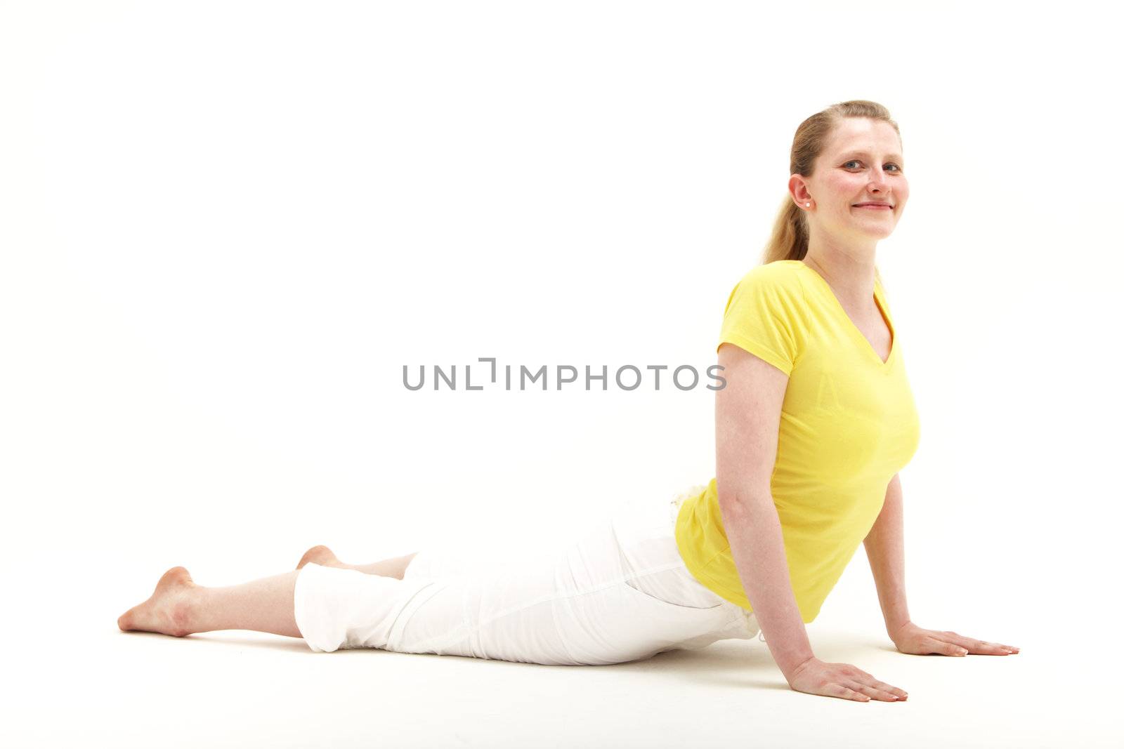 Fit healthy woman full of vitality smiling happily while doing pressups on the floor, studio portrait on white 