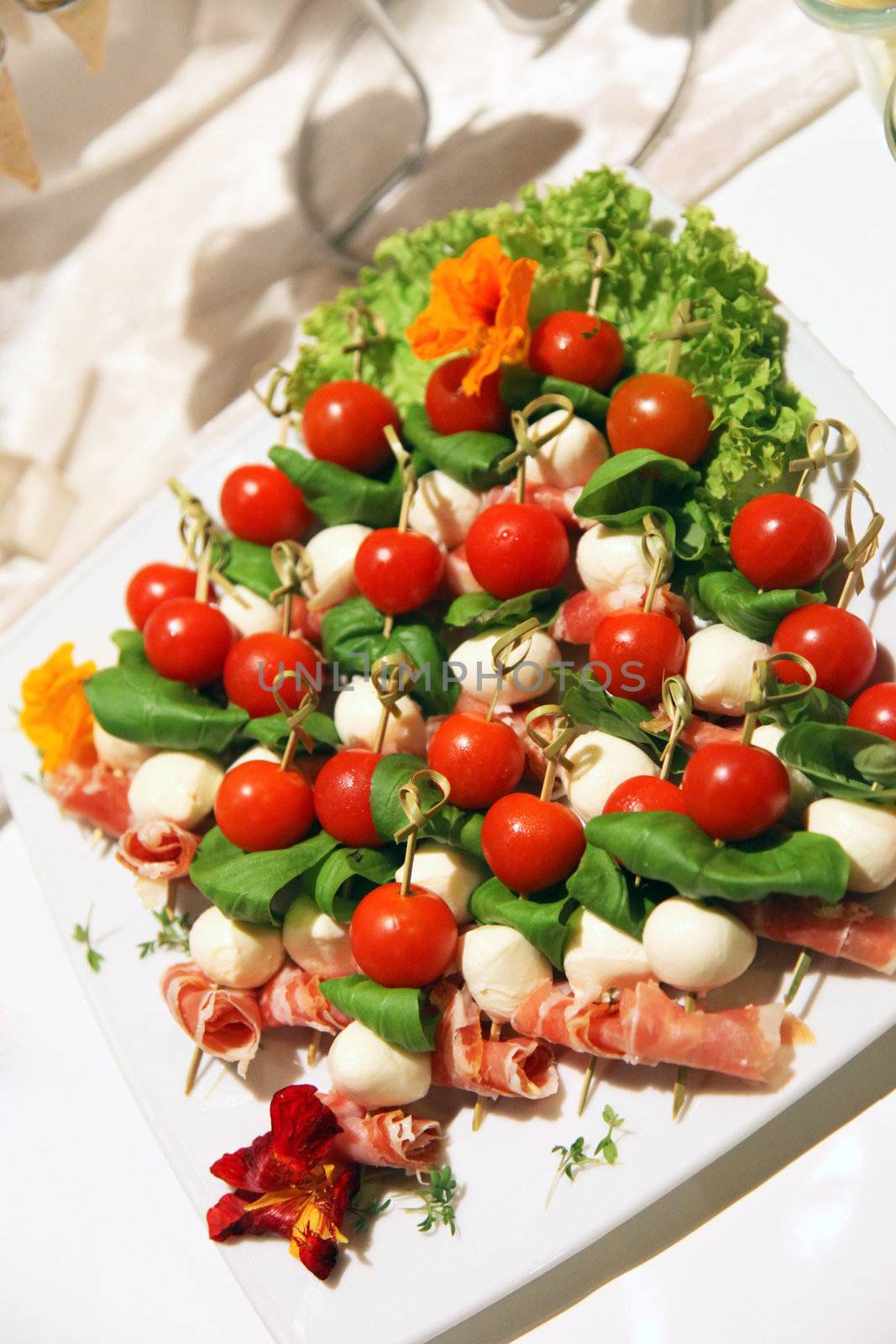 Catering display of colouful appetizers with fresh cherry tomatoes, mushrooms and rolled ham served on a plate at a cold buffet Catering display of colouful appetizers with fresh cherry tomatoes, mushrooms and rolled ham served on a plate 