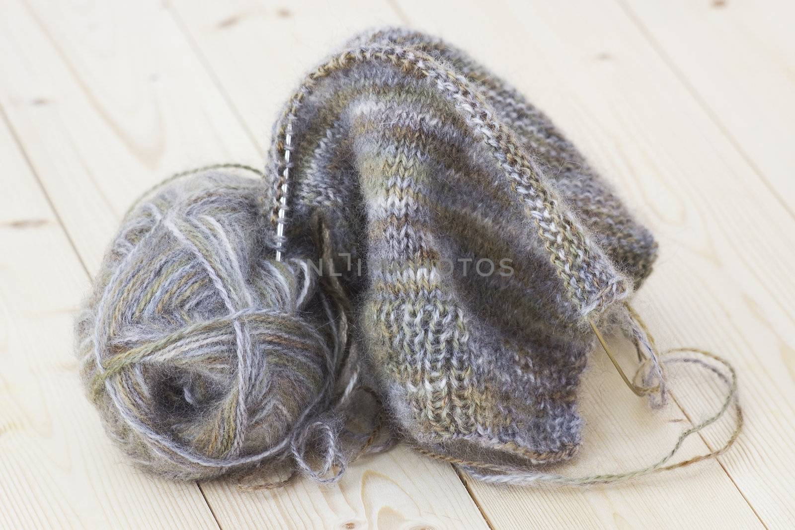 Woollen thread and knitting needle.