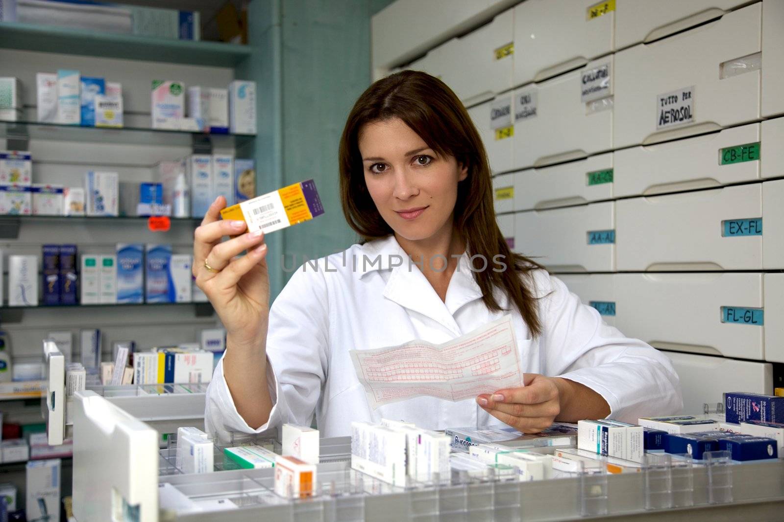 Beautiful pharmacist woman showing medicine by fmarsicano