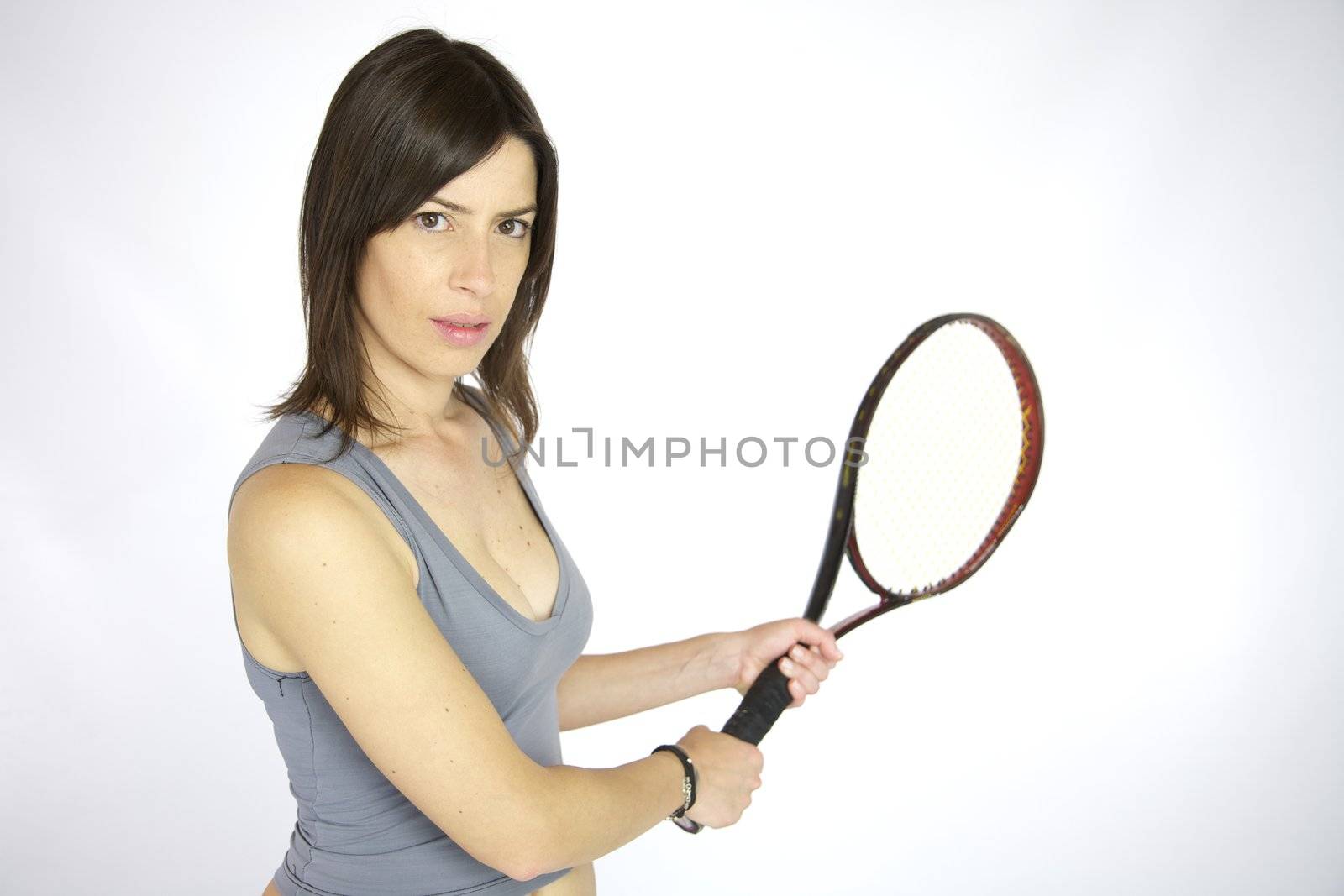 Beautiful woman concentrated play tennis in studio