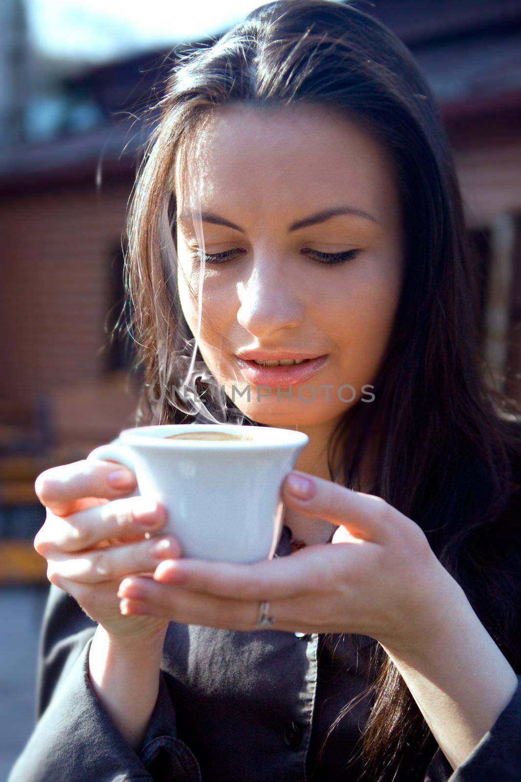 Portrait of beautiful brunette woman drinking hot cappuccino