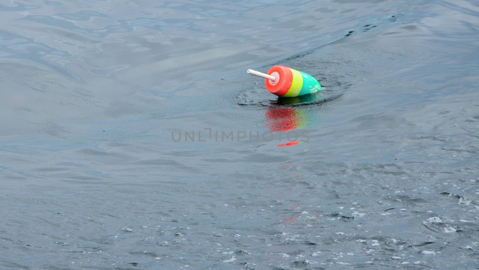 A colorful lobster bouy marking a trap below the water