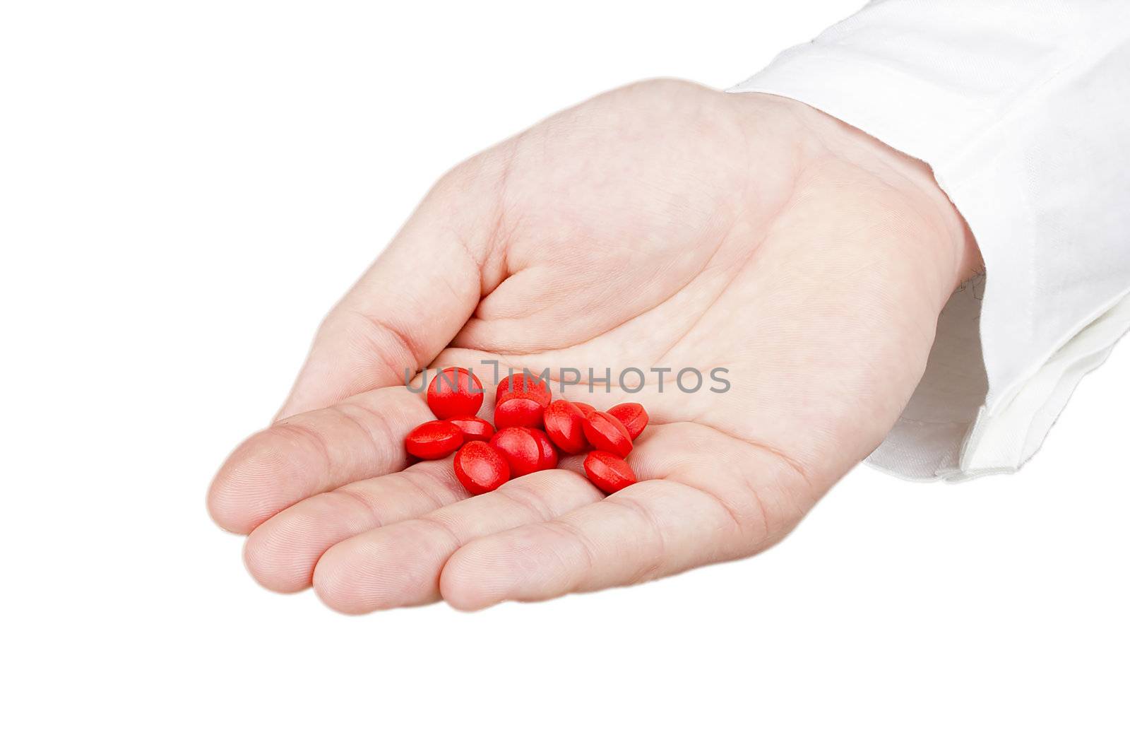 Close-up photograph of a hand holding red tablets.