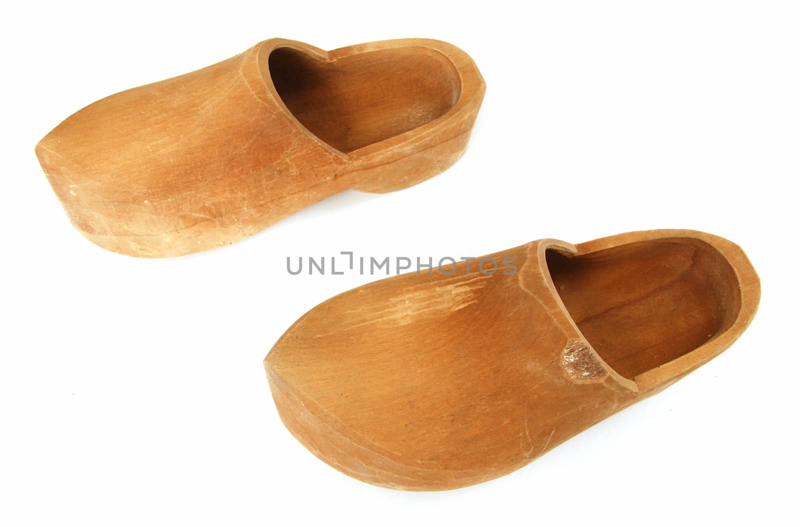 A pair of ancient wooden shoes on white 