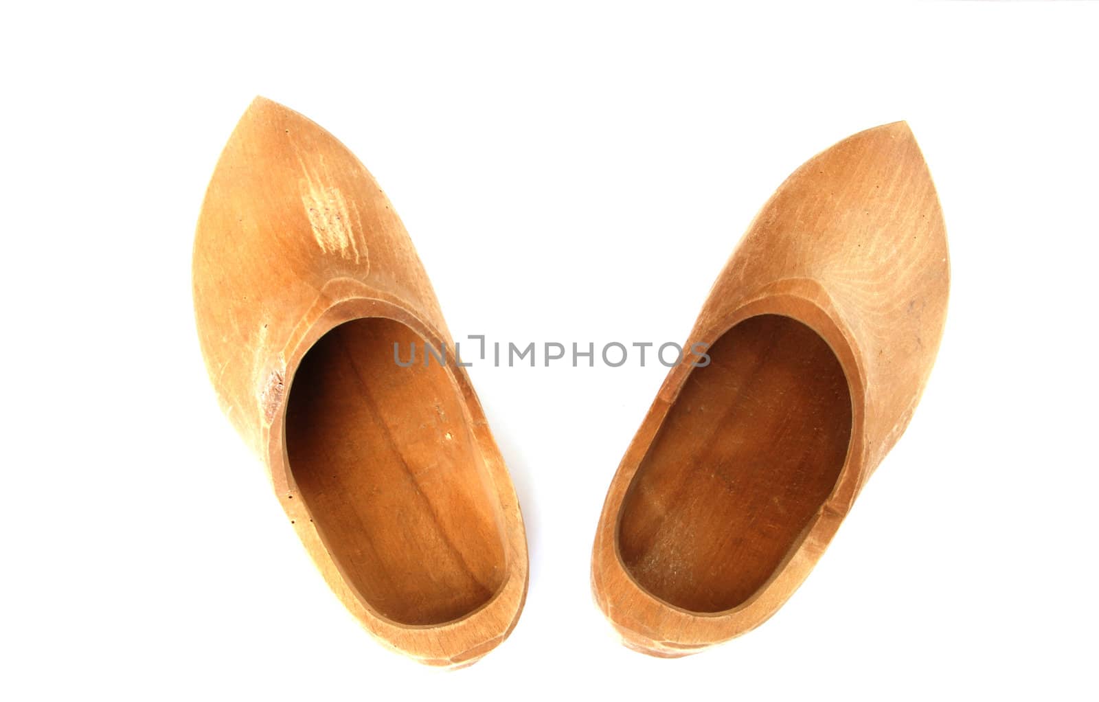 A pair of ancient wooden shoes on white 